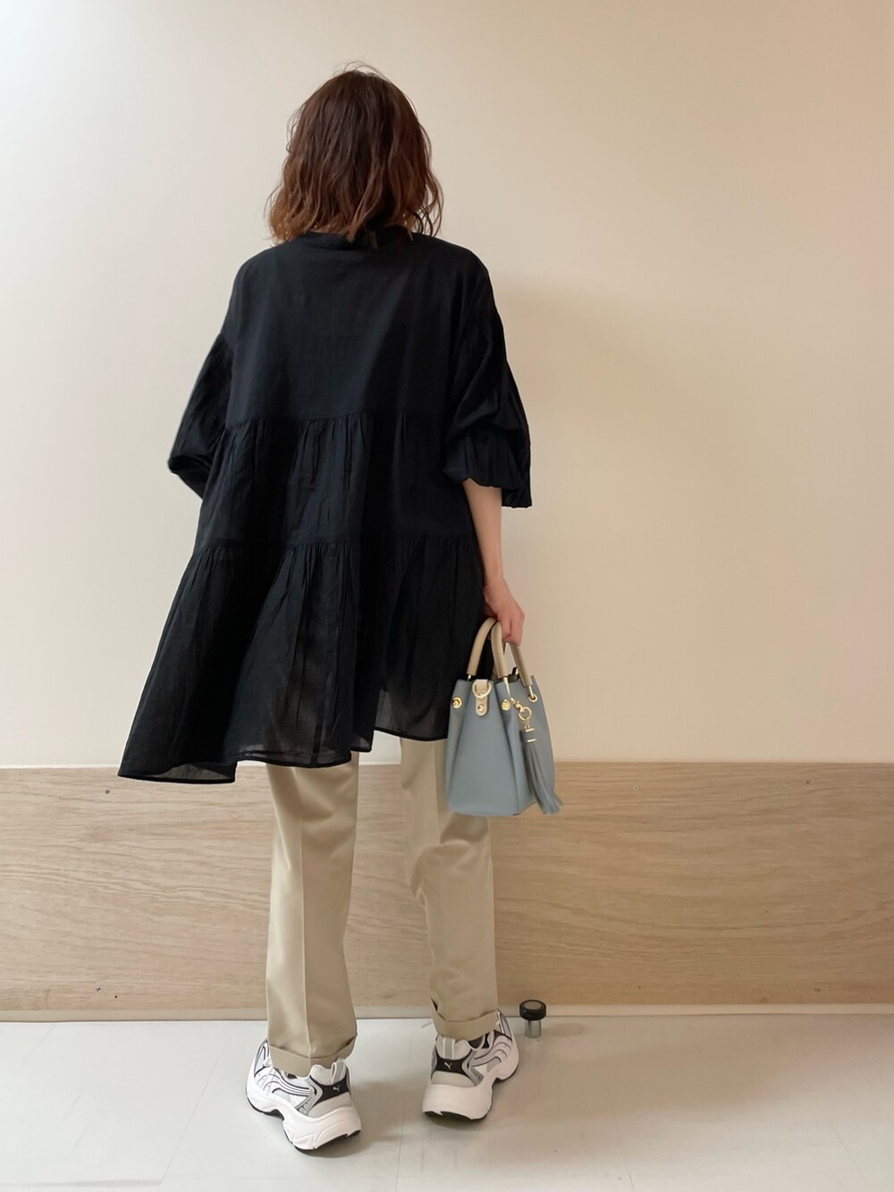 ブラック系のチュニック、ベージュ系のその他パンツを着用したレディースの春コーディネートの7枚目の写真