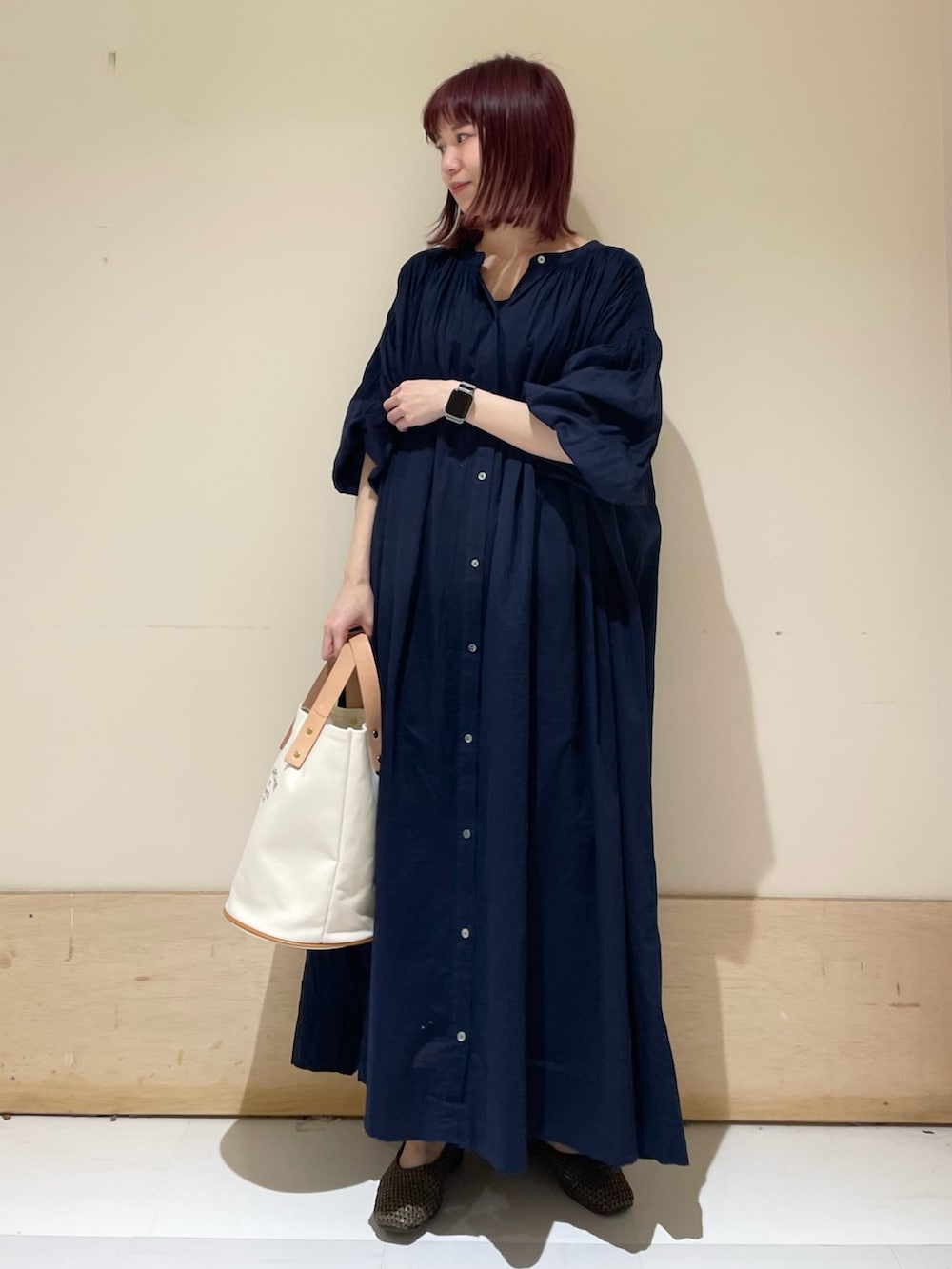 ホワイト系のトートバッグ、ブルー系のワンピース、ブラウン系のパンプスを着用したレディースの春コーディネートの3枚目の写真