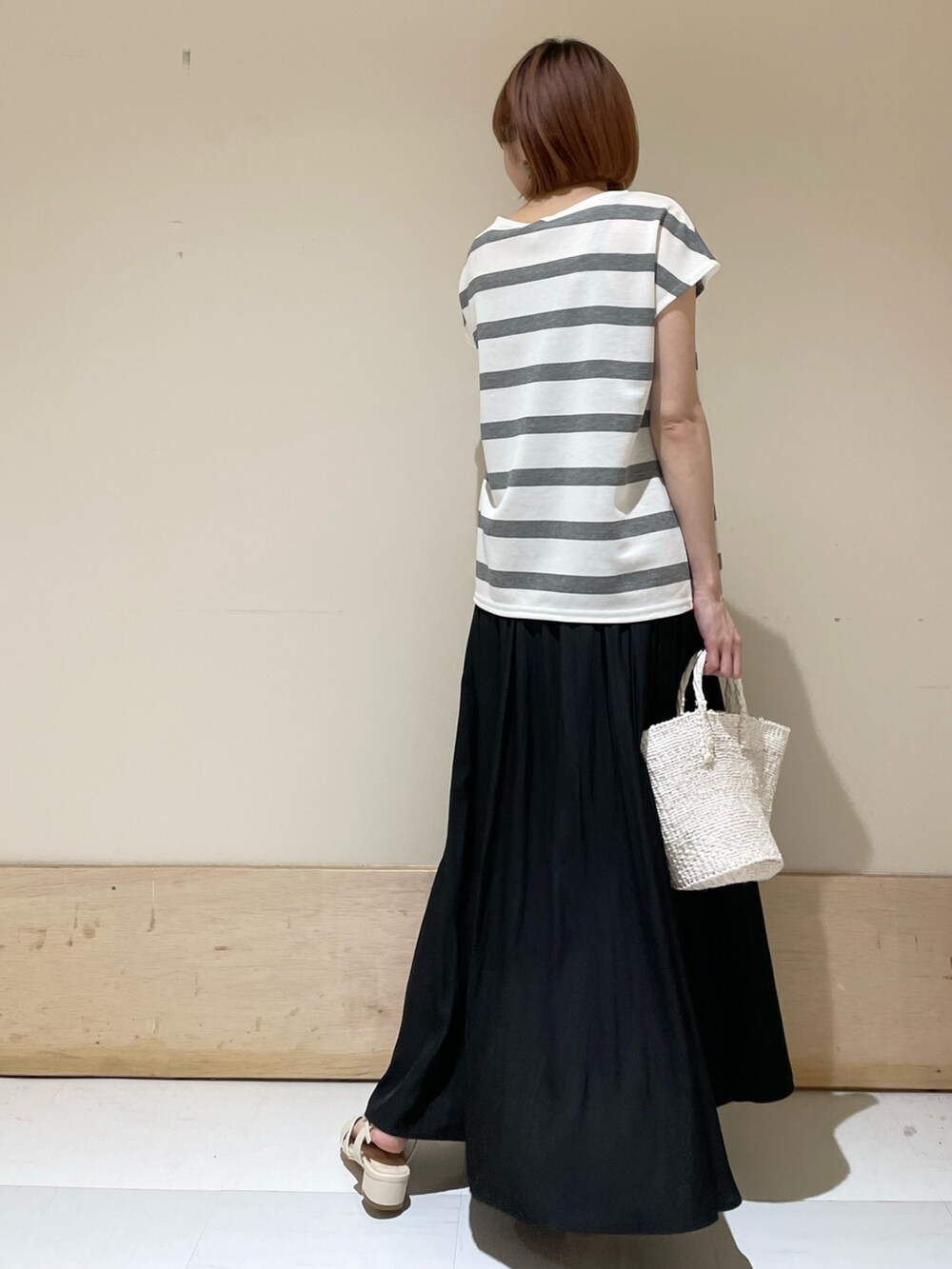 グレー系のTシャツ/カットソー、ホワイト系のハンドバッグ、ホワイト系のサンダルを着用したレディースの春コーディネートの7枚目の写真