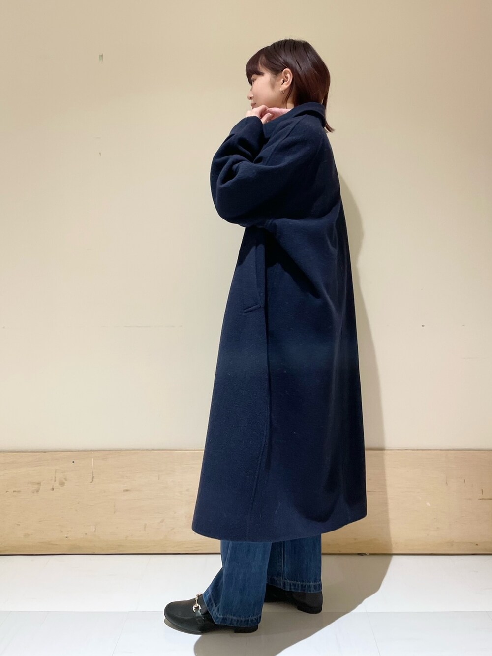 ブルー系のデニムパンツ、ピンク系のニット/セーター、ブルー系のステンカラーコートを着用したレディースの冬コーディネートの4枚目の写真