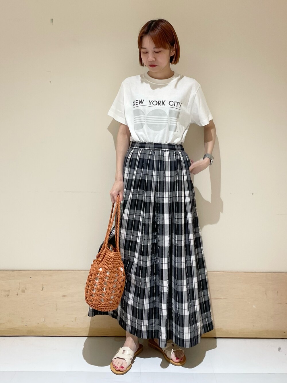 ブラック系のスカート、グレー系のTシャツ/カットソー、ブラウン系のかごバッグを着用したレディースの春コーディネートの5枚目の写真