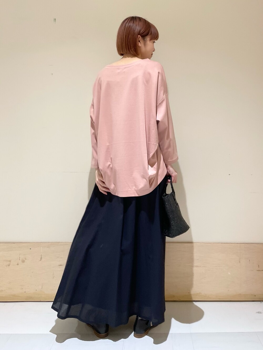ピンク系のTシャツ/カットソー、ブルー系のスカート、ブラック系のハンドバッグを着用したレディースの春コーディネートの8枚目の写真