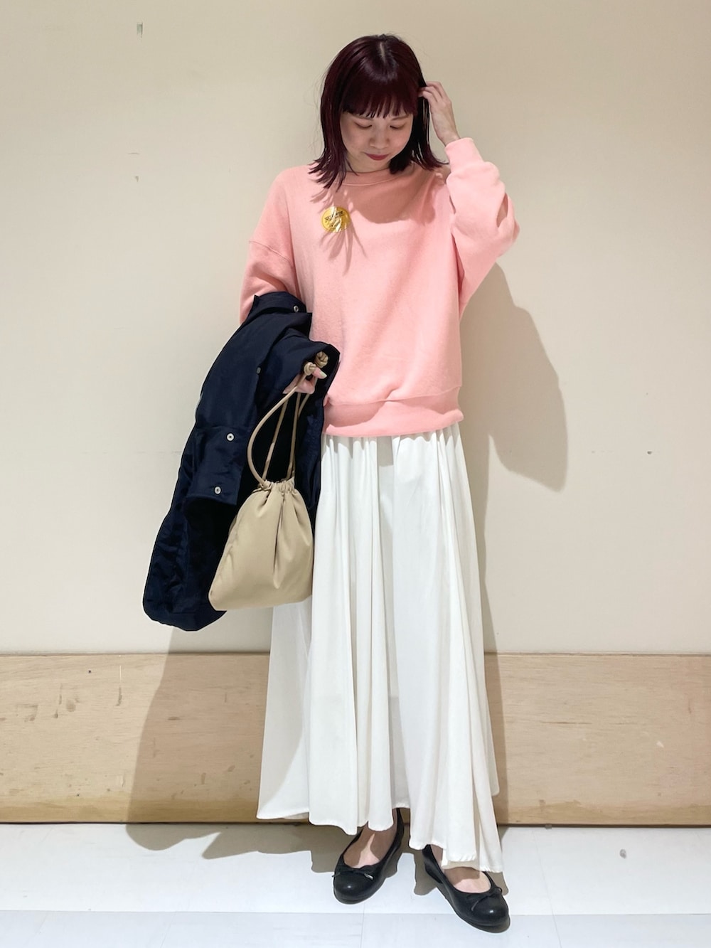 ピンク系のスウェット、ブルー系のその他アウター、ホワイト系のスカートを着用したレディースの春コーディネートの2枚目の写真