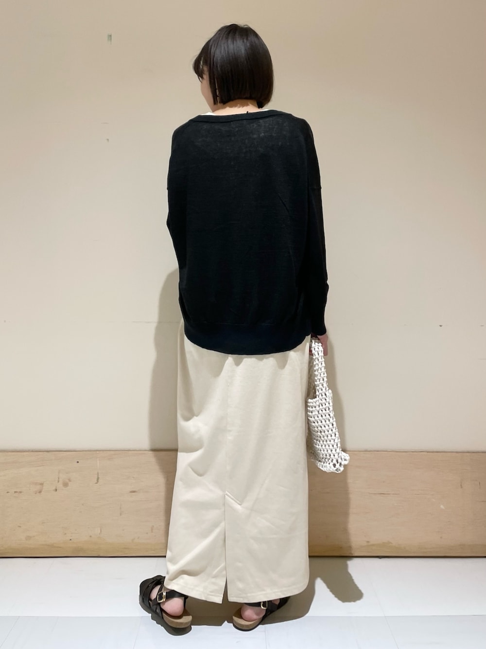 ベージュ系のワンピース、ブラック系のカーディガン/ボレロ、ブラック系のサンダルを着用したレディースの夏コーディネートの6枚目の写真