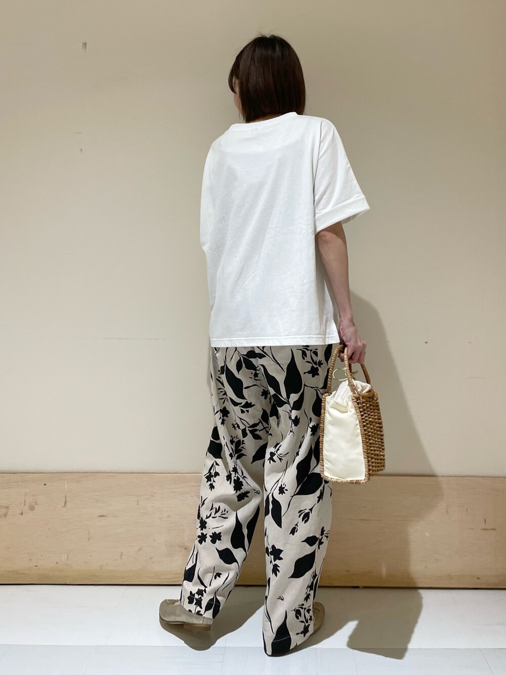 ベージュ系のその他パンツ、ホワイト系のTシャツ/カットソー、ベージュ系のハンドバッグを着用したレディースの夏コーディネートの6枚目の写真