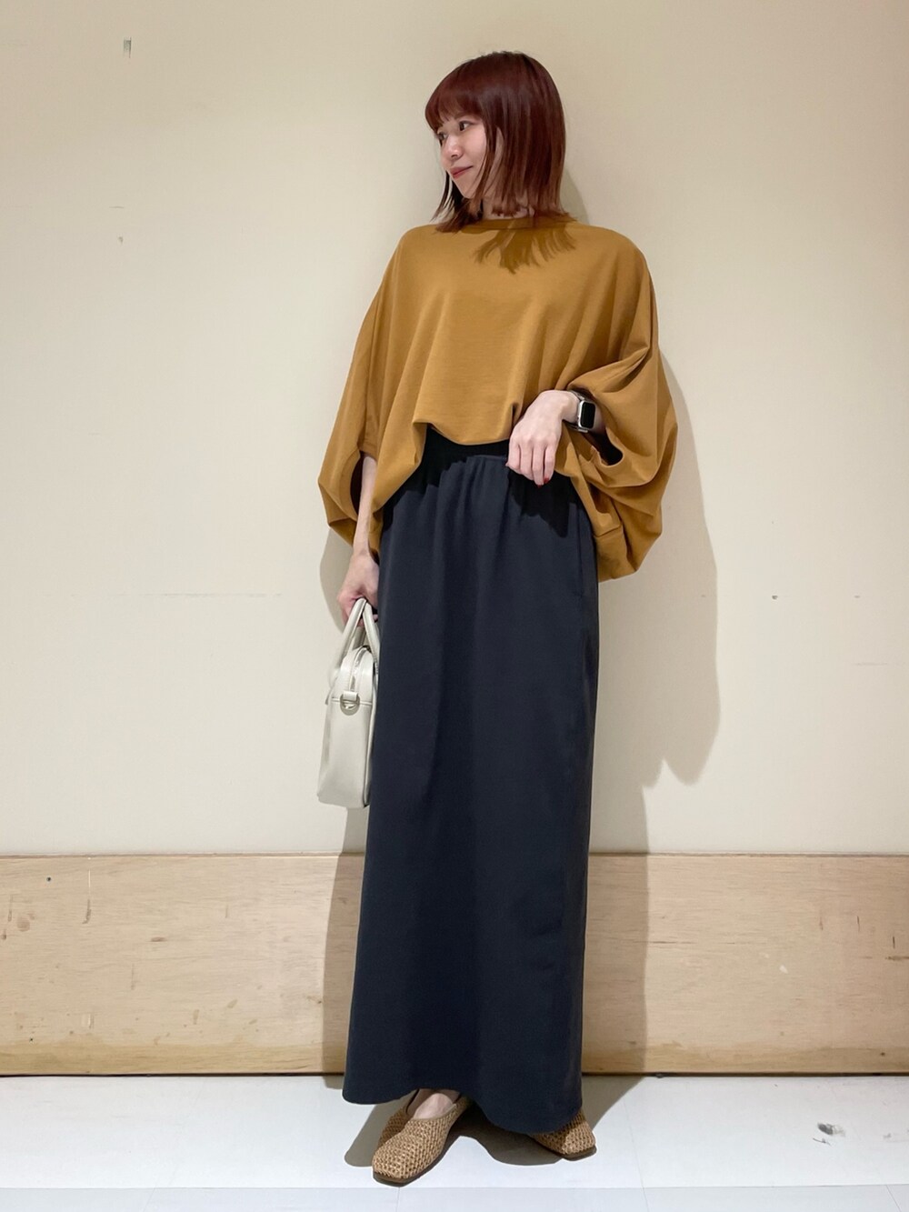 イエロー系のTシャツ/カットソー、ベージュ系のパンプス、グレー系のスカートを着用したレディースの春コーディネートの2枚目の写真