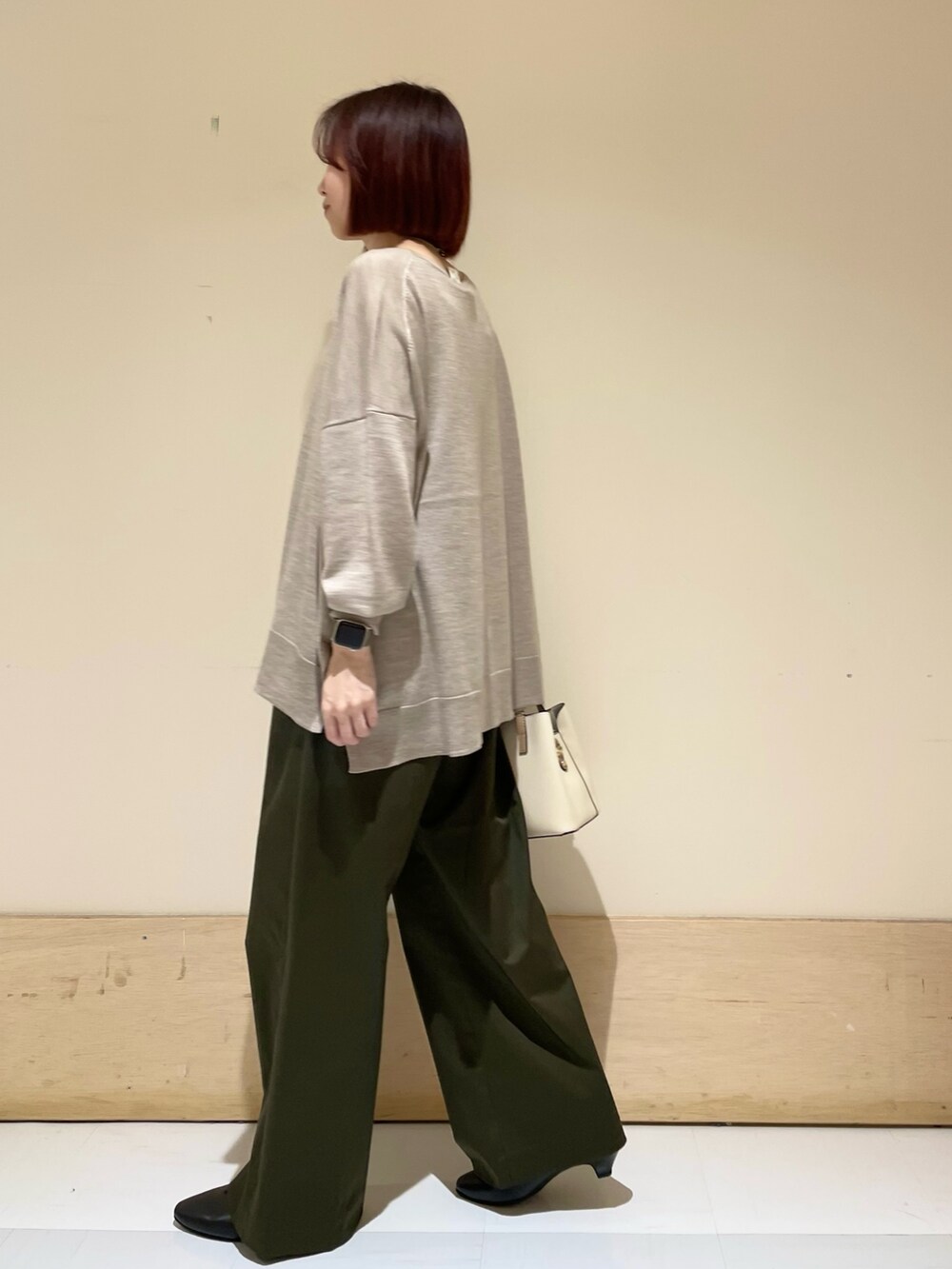 ブラック系のパンプス、ベージュ系のニット/セーター、ホワイト系のハンドバッグを着用したレディースの秋コーディネートの6枚目の写真