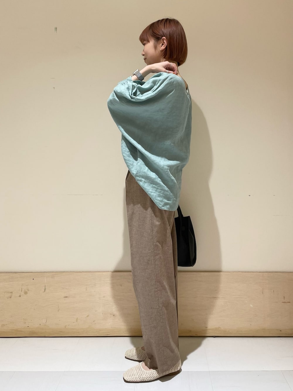 グリーン系のシャツ/ブラウス、ブラック系のトートバッグ、ホワイト系のバレエシューズを着用したレディースの春コーディネートの5枚目の写真