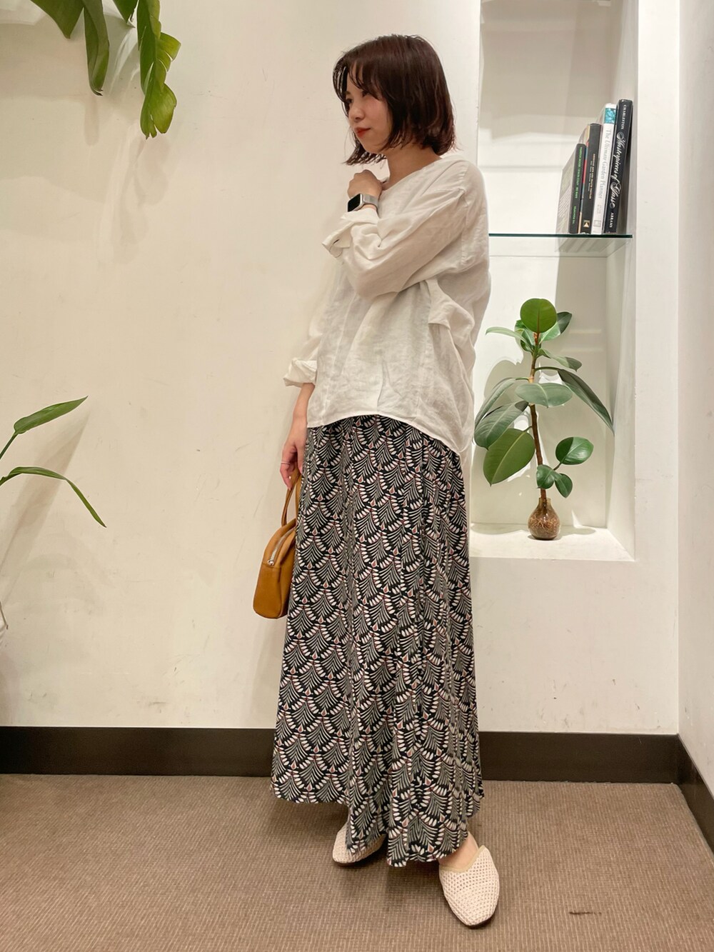 ホワイト系のサンダル、ホワイト系のシャツ/ブラウス、グリーン系のスカートを着用したレディースの春コーディネートの2枚目の写真