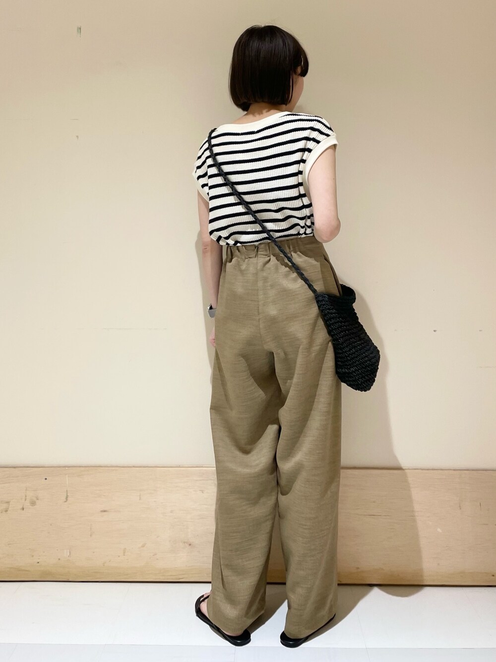 ベージュ系のその他パンツ、ブラック系のショルダーバッグ、ホワイト系のTシャツ/カットソーを着用したレディースの夏コーディネートの7枚目の写真