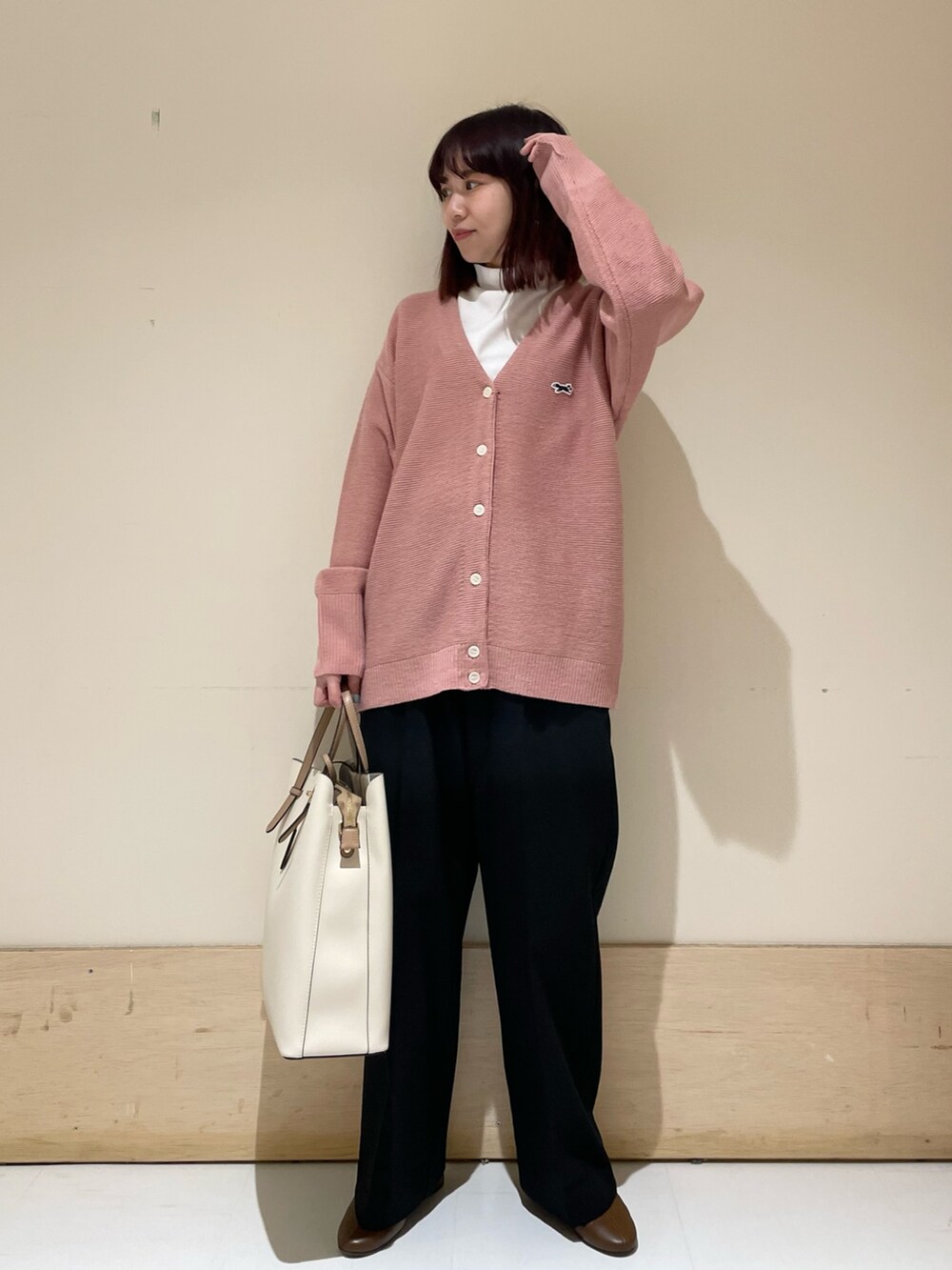 ピンク系のカーディガン/ボレロ、ホワイト系のTシャツ/カットソー、ブラック系のその他パンツを着用したレディースの冬コーディネートの2枚目の写真