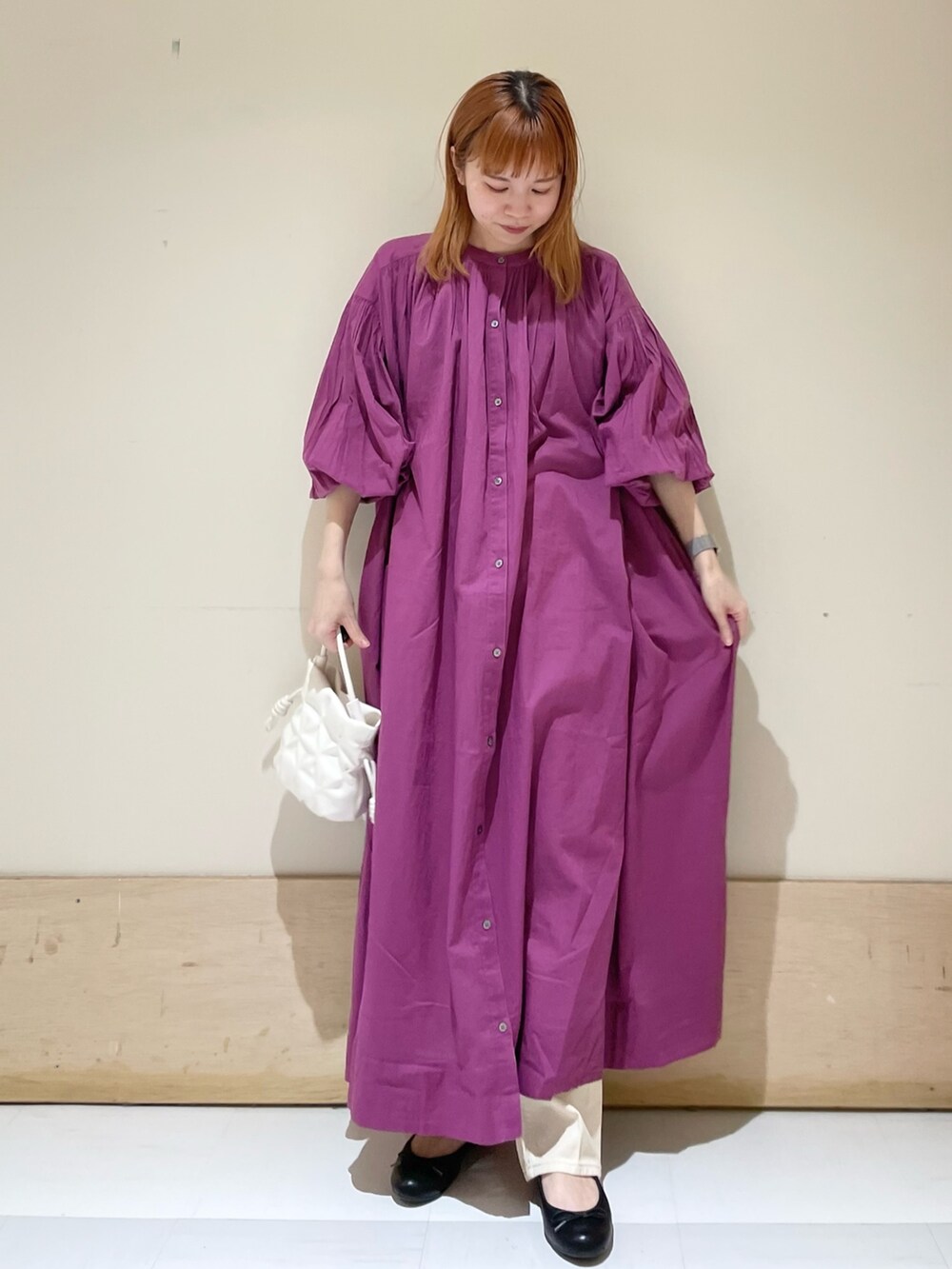 ベージュ系のデニムパンツ、パープル系のワンピース、ホワイト系のショルダーバッグを着用したレディースの春コーディネートの3枚目の写真