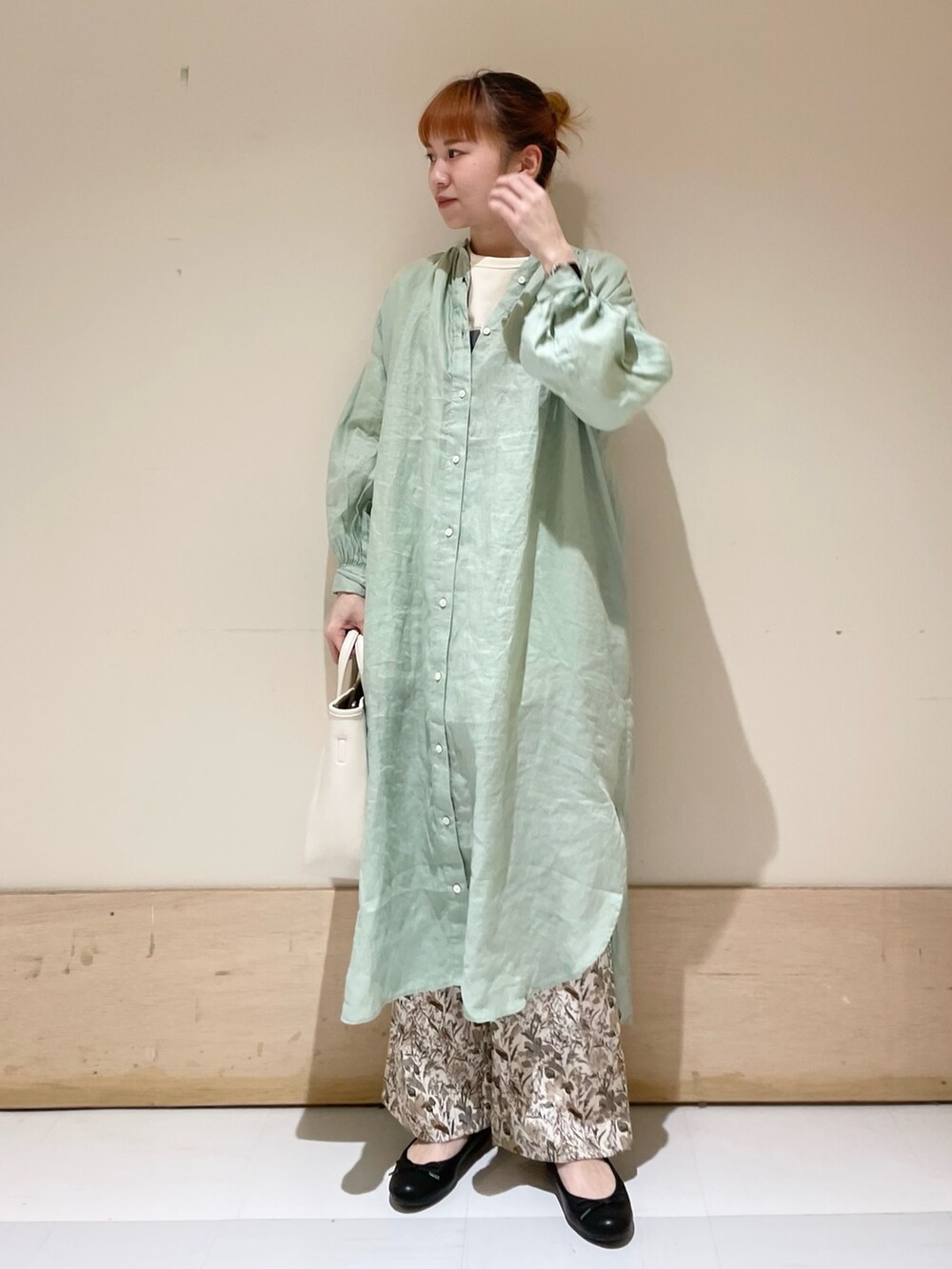 グリーン系のワンピース、ホワイト系のTシャツ/カットソー、ホワイト系のトートバッグを着用したレディースの春コーディネートの2枚目の写真