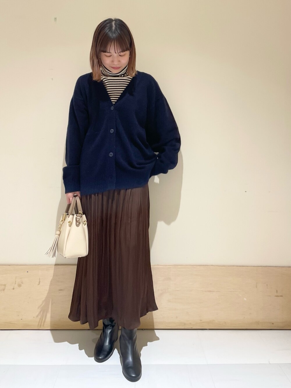 ブルー系のカーディガン/ボレロ、ホワイト系のニット/セーター、ブラウン系のスカートを着用したレディースの冬コーディネートの3枚目の写真