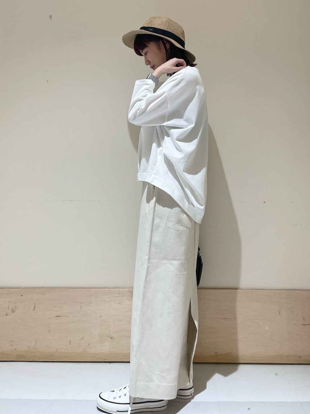 ホワイト系のTシャツ/カットソー、ホワイト系のスニーカー、ブラック系のショルダーバッグを着用したレディースの春コーディネートの4枚目の写真