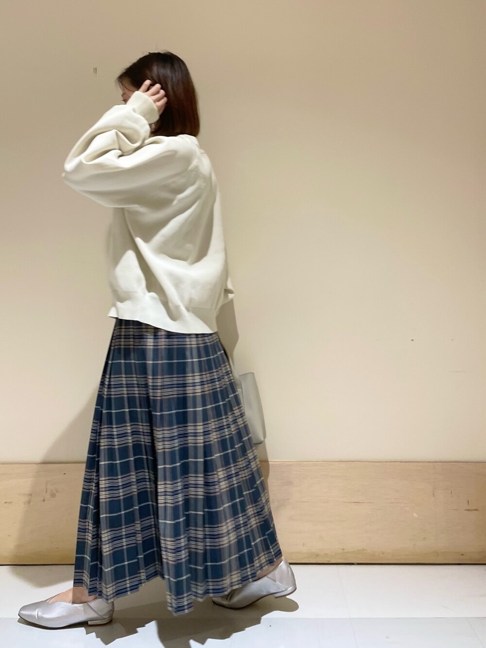 ホワイト系のニット/セーター、グレー系のトートバッグ、ブルー系のスカートを着用したレディースの秋コーディネートの4枚目の写真