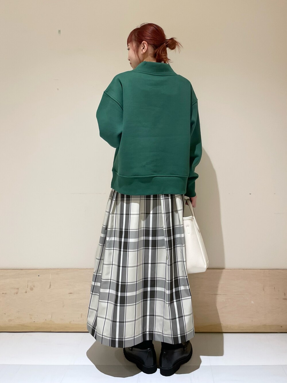 グリーン系のスウェット、ベージュ系のスカート、ブラック系のローファーを着用したレディースの冬コーディネートの5枚目の写真