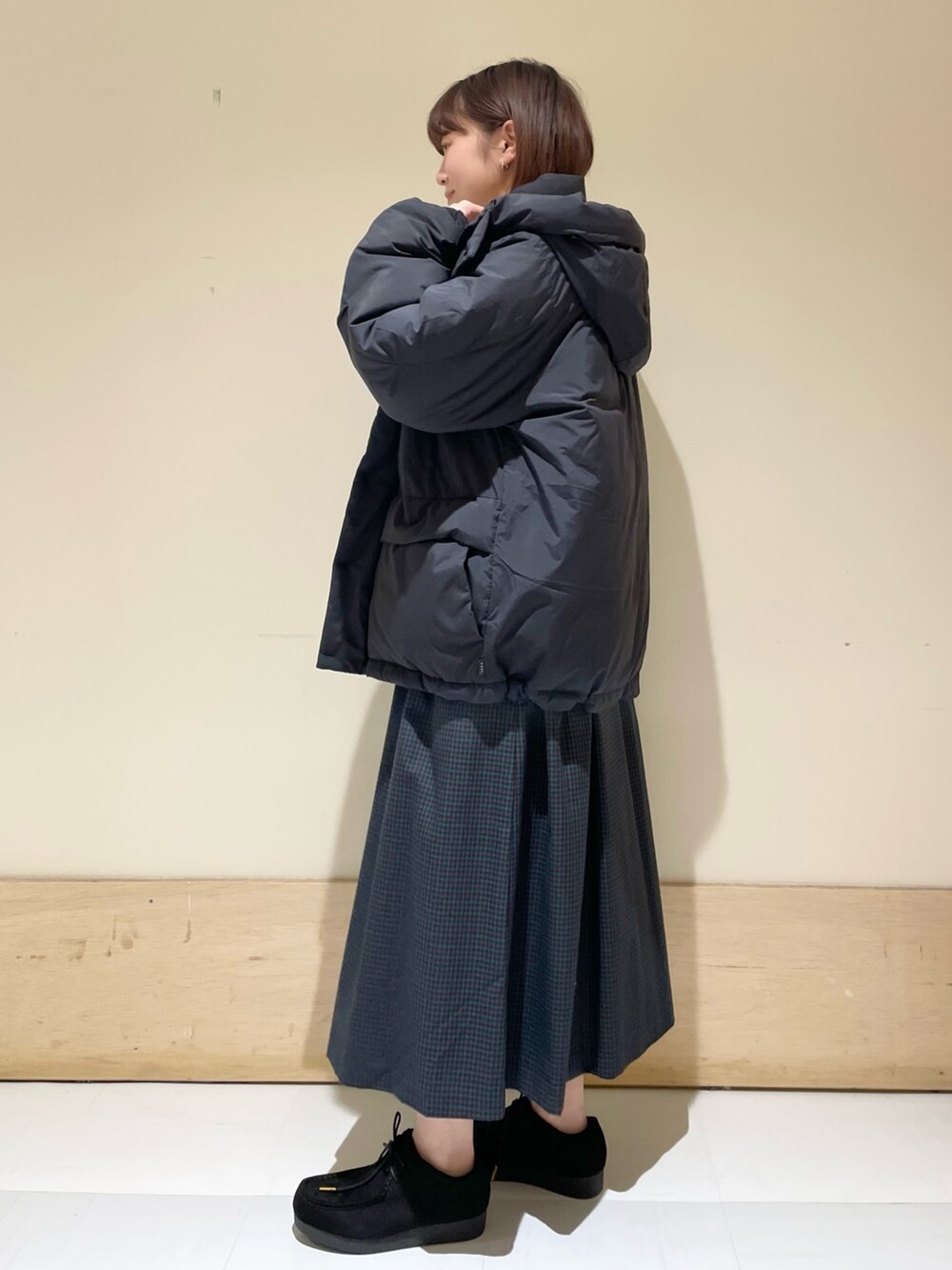 ブルー系のワンピース、ブラック系のダウンジャケット/コート、ホワイト系のTシャツ/カットソーを着用したレディースの冬コーディネートの4枚目の写真