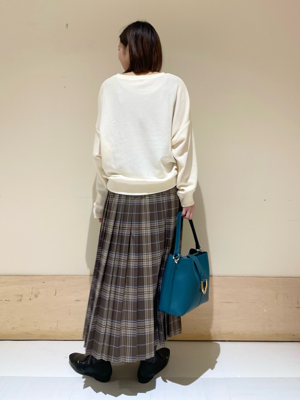 ブルー系のハンドバッグ、ブラック系のローファー、ベージュ系のTシャツ/カットソーを着用したレディースの秋コーディネートの6枚目の写真