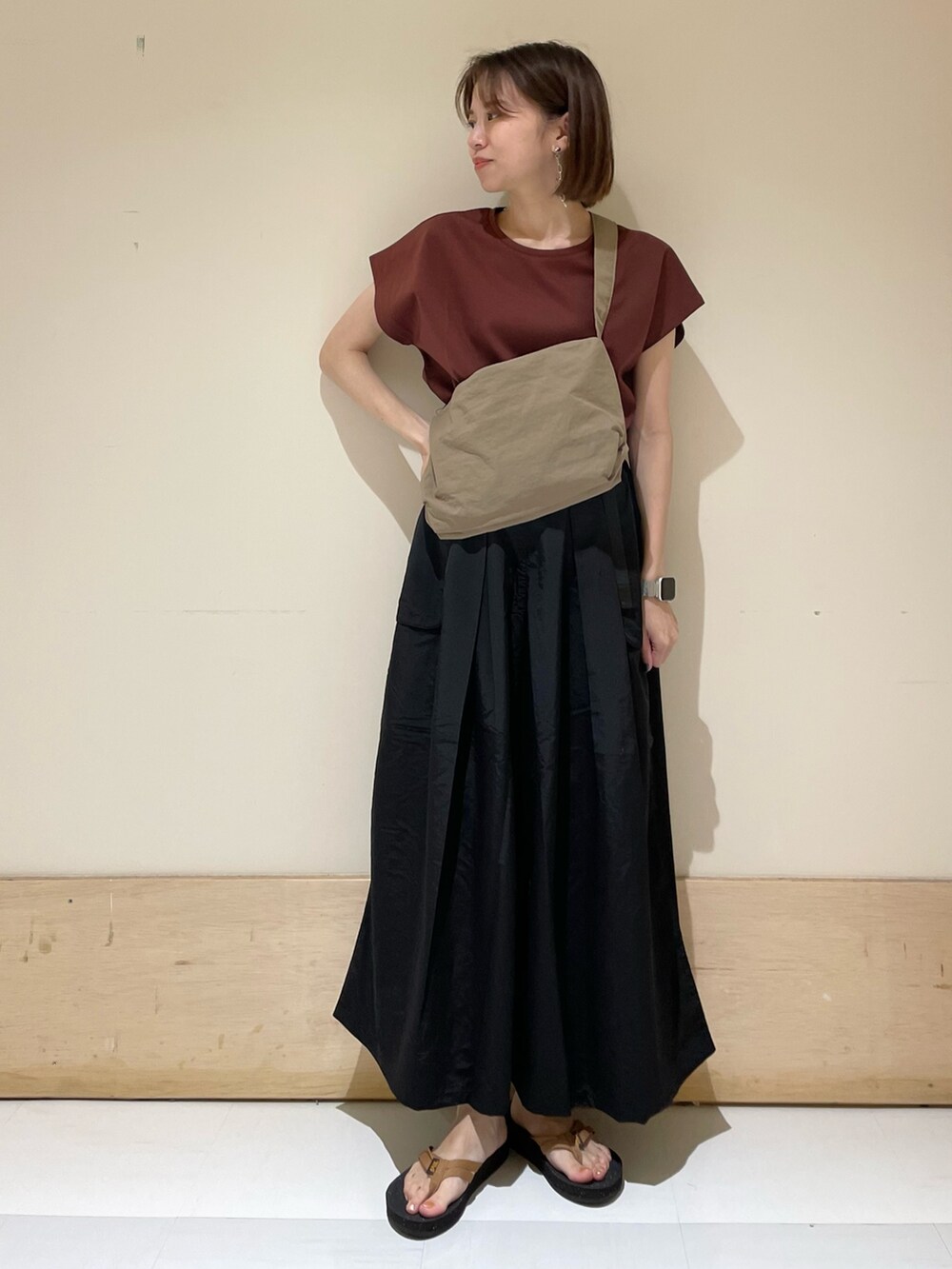 レッド系のTシャツ/カットソー、オレンジ系のサンダル、ベージュ系のショルダーバッグを着用したレディースの夏コーディネートの3枚目の写真