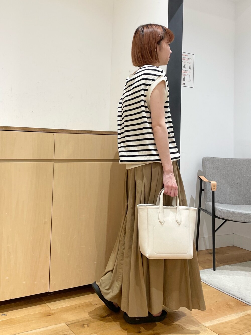 ホワイト系のTシャツ/カットソー、ベージュ系のスカート、ホワイト系のトートバッグを着用したレディースの春コーディネートの5枚目の写真