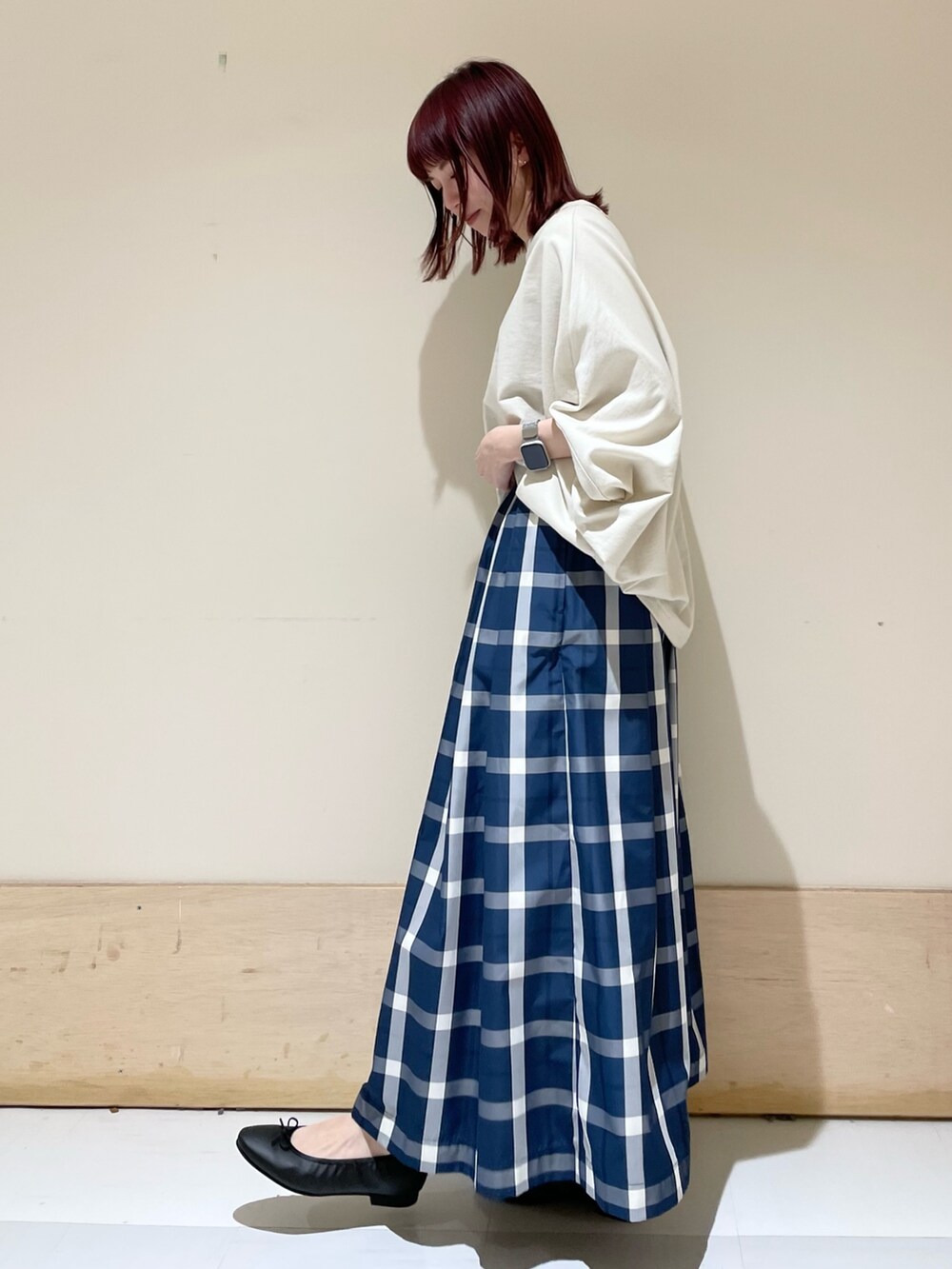 ベージュ系のTシャツ/カットソー、ブルー系のスカート、ブラック系のトートバッグを着用したレディースの春コーディネートの4枚目の写真