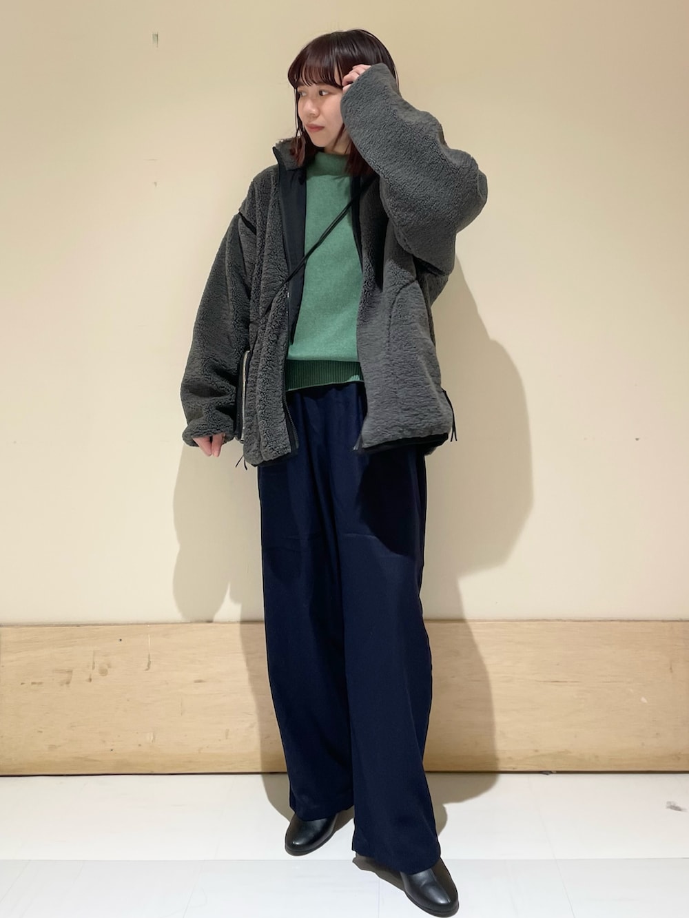 グリーン系のニット/セーター、グレー系のブルゾン、ブルー系のその他パンツを着用したレディースの冬コーディネートの3枚目の写真