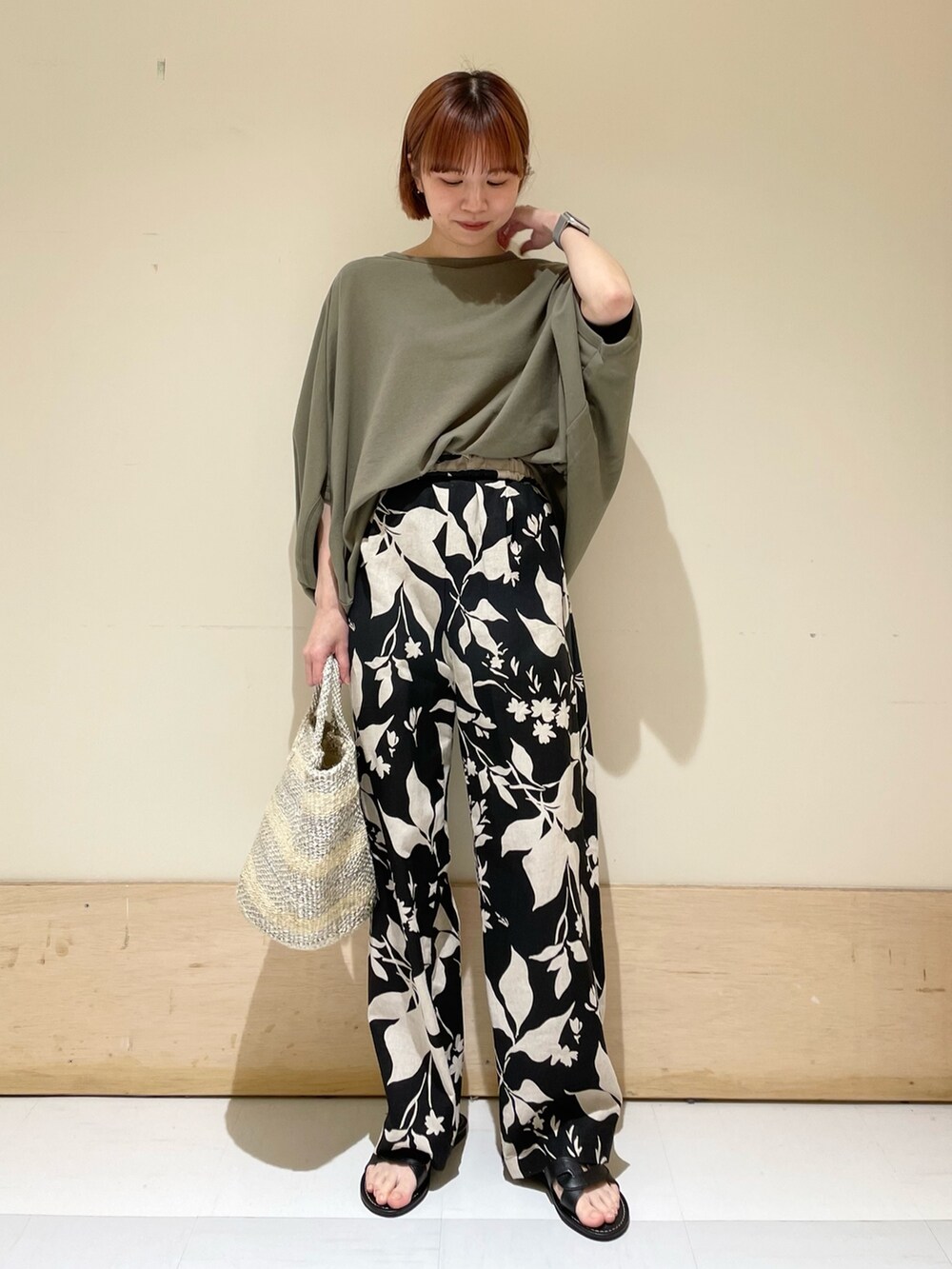 ブラック系のその他パンツ、グリーン系のTシャツ/カットソー、ホワイト系のハンドバッグを着用したレディースの春コーディネートの2枚目の写真