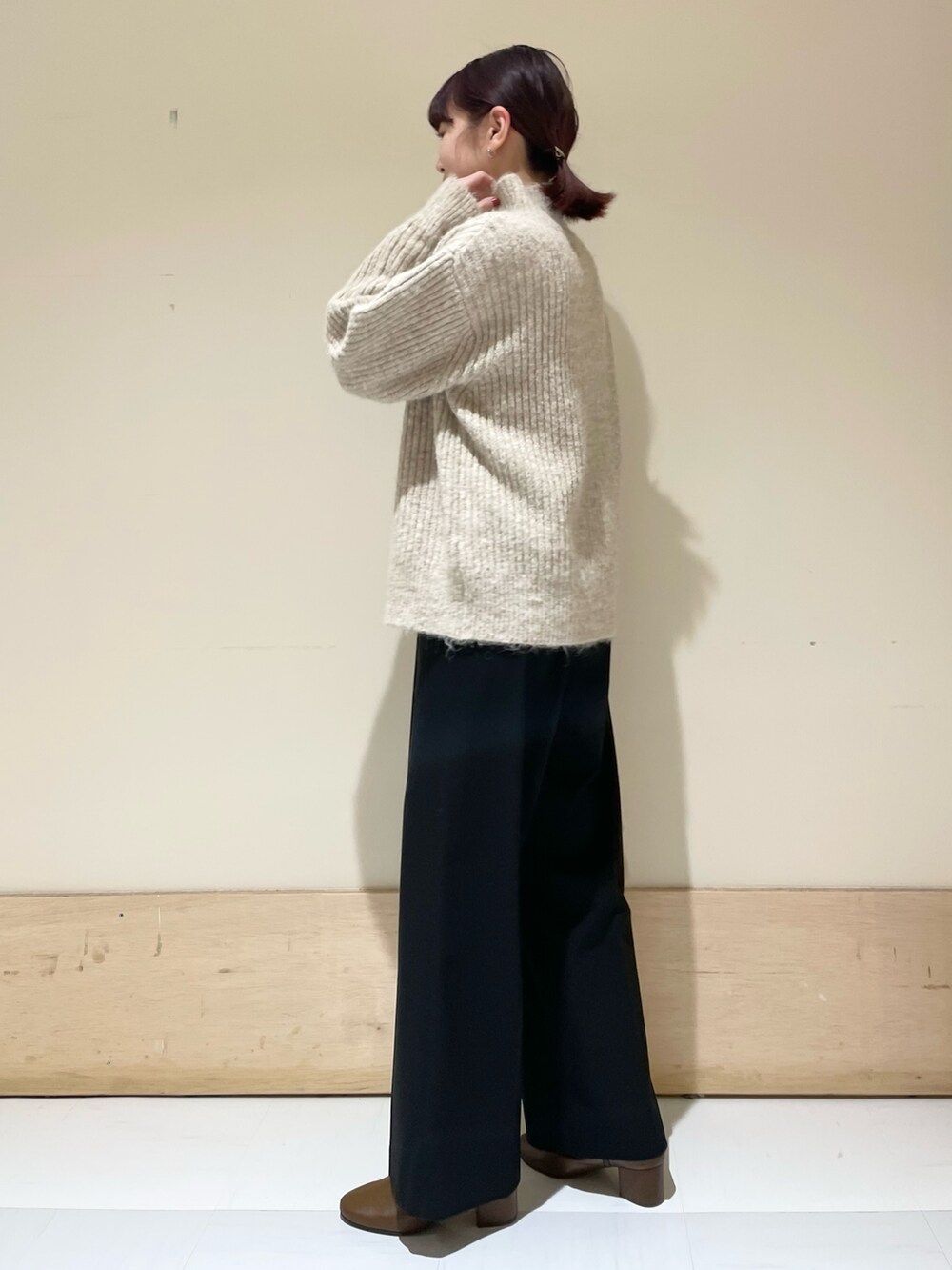 ブラック系のその他パンツ、ベージュ系のニット/セーター、ベージュ系のハンドバッグを着用したレディースの冬コーディネートの2枚目の写真