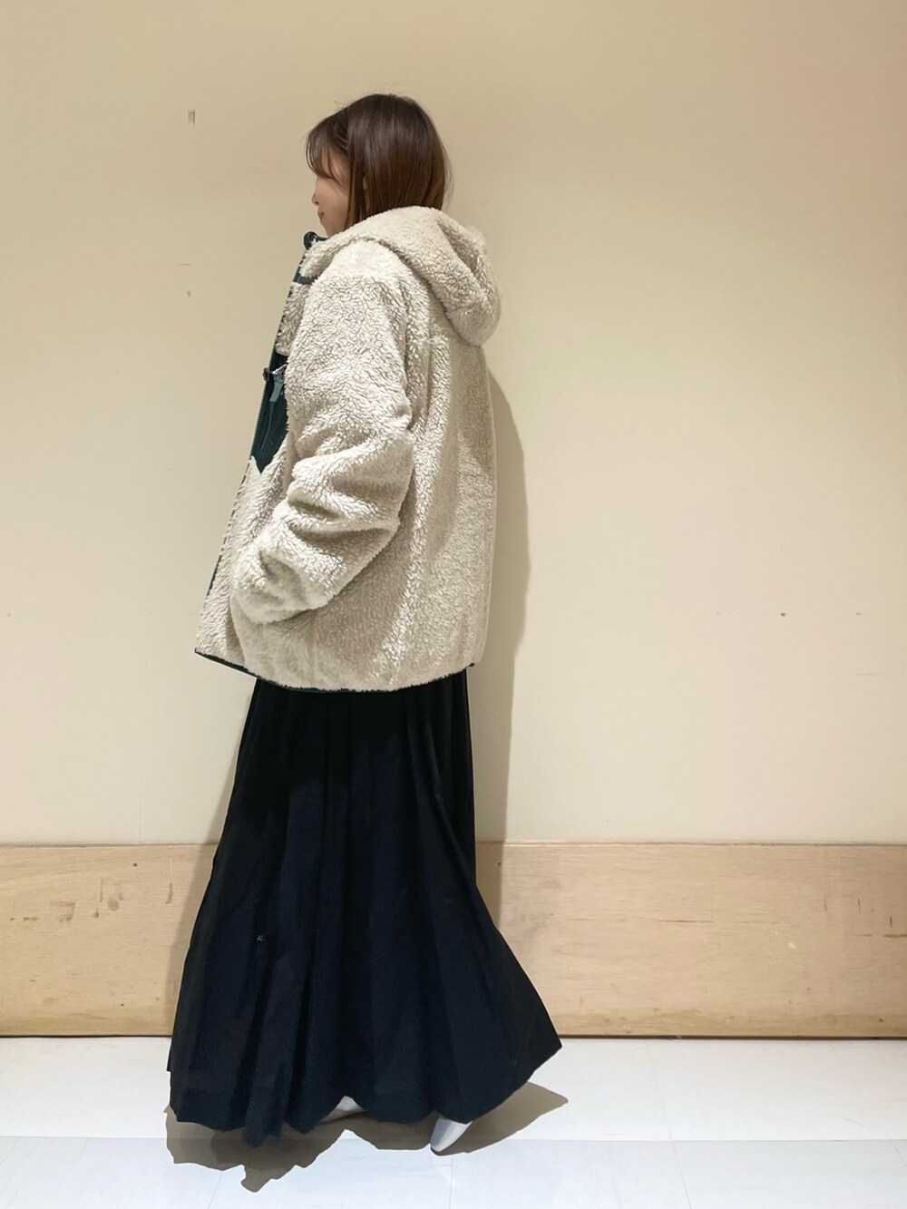 シルバー系のパンプス、ブルー系のTシャツ/カットソー、ベージュ系のハンドバッグを着用したレディースの秋コーディネートの6枚目の写真