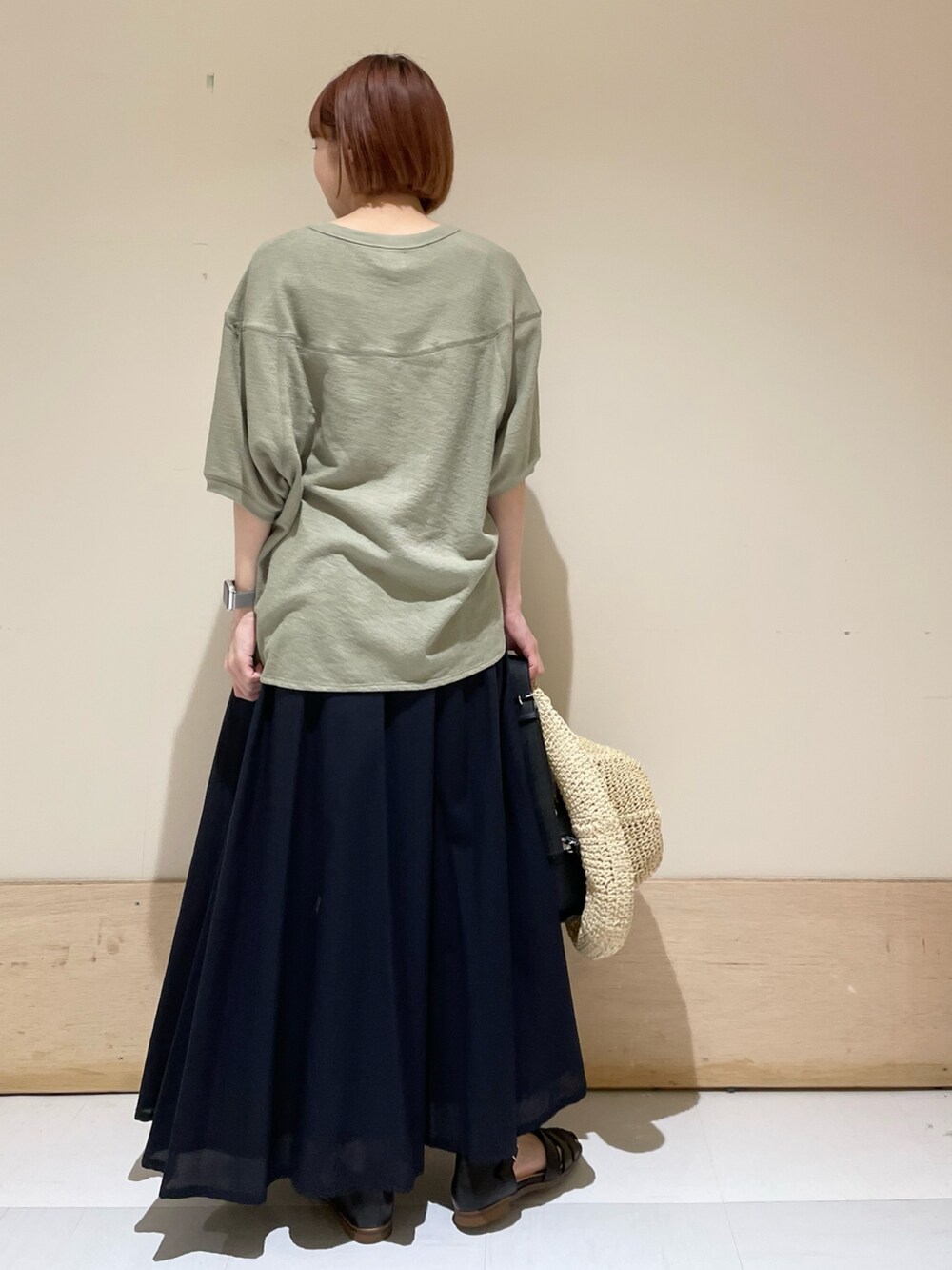 ブルー系のスカート、ブラック系のサンダル、グリーン系のTシャツ/カットソーを着用したレディースの春コーディネートの7枚目の写真