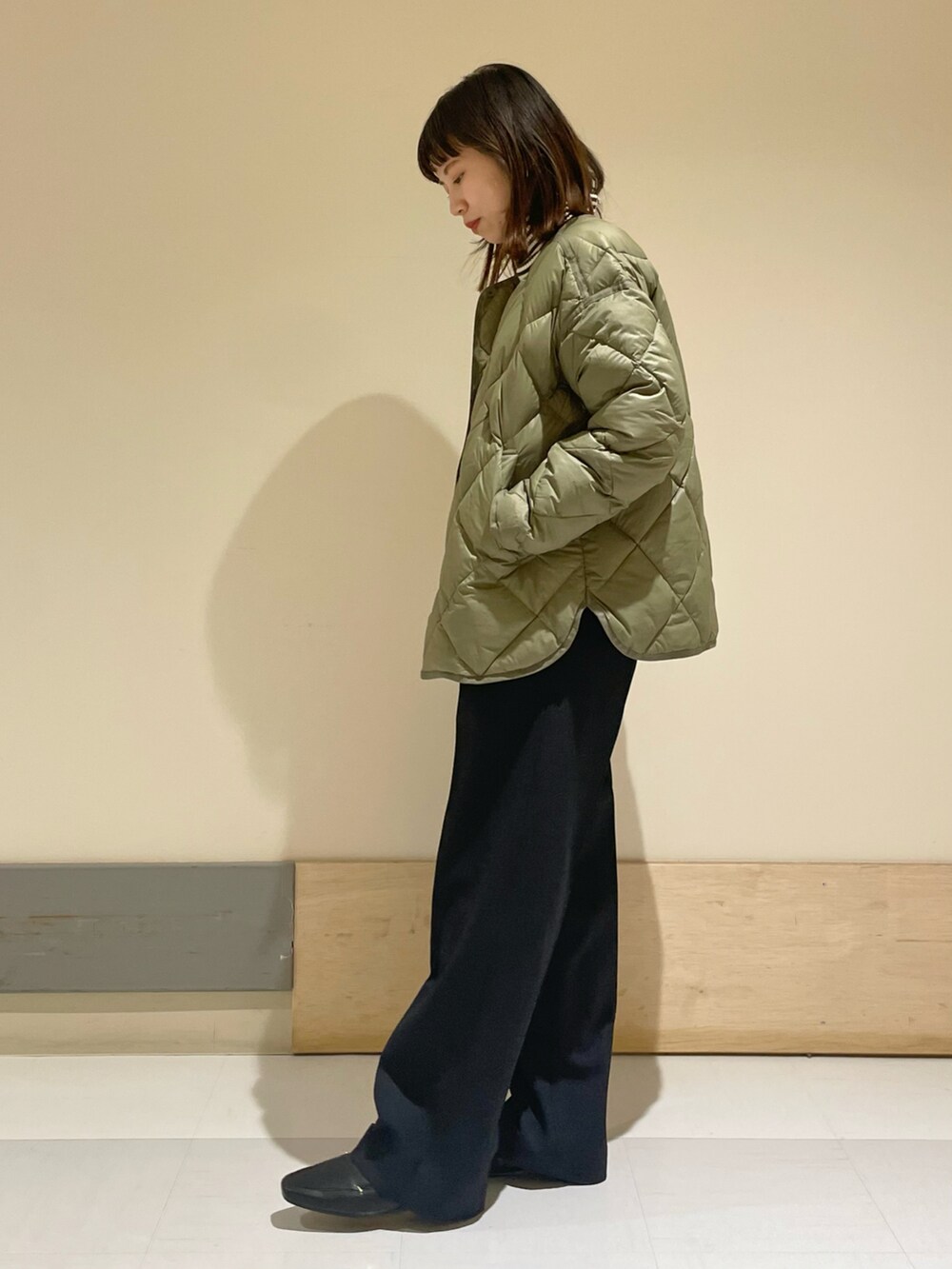 グリーン系のダウンジャケット/コート、ブラウン系のニット/セーター、ブルー系のその他パンツを着用したレディースの冬コーディネートの2枚目の写真