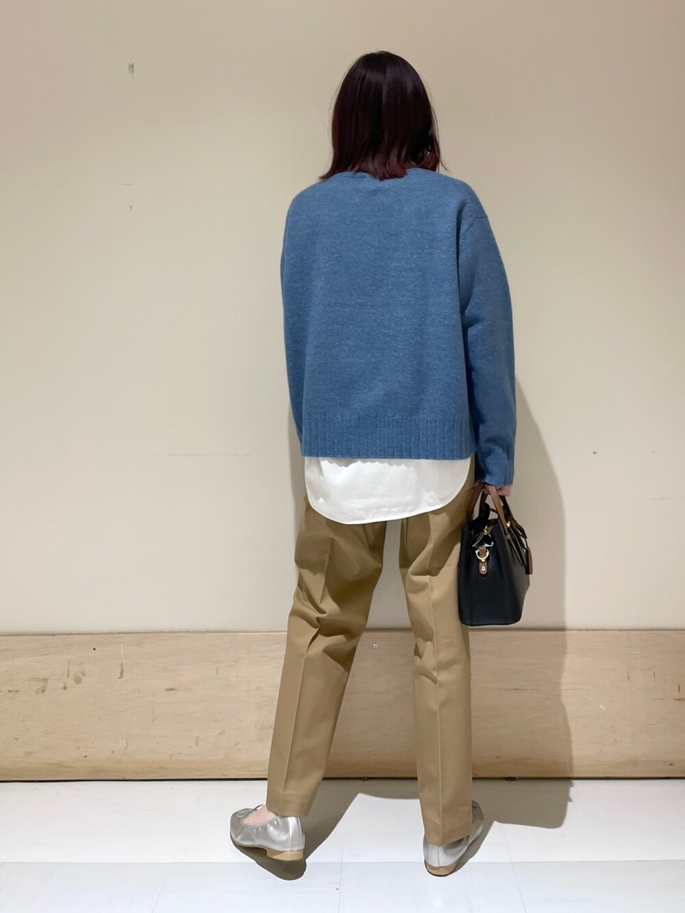 ホワイト系のTシャツ/カットソー、ブルー系のニット/セーター、シルバー系のバレエシューズを着用したレディースの冬コーディネートの6枚目の写真