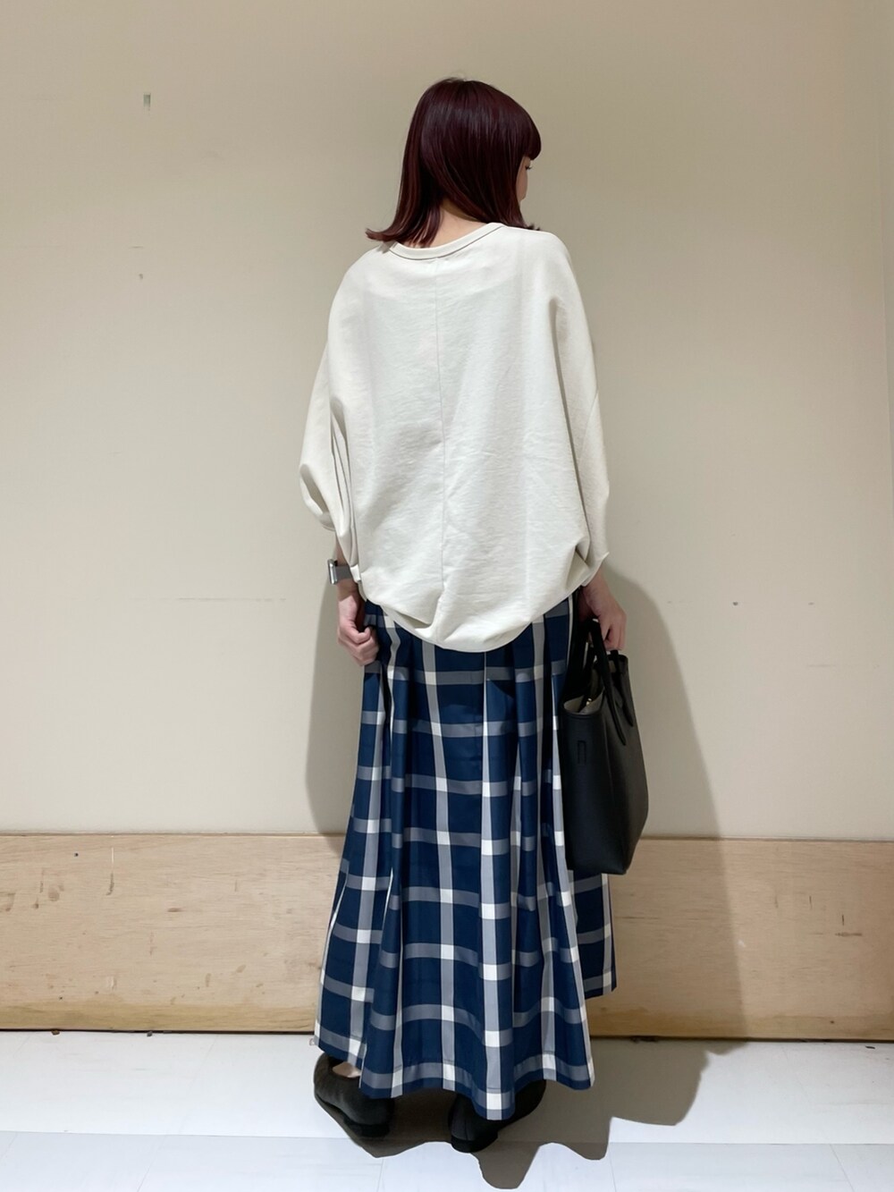 ベージュ系のTシャツ/カットソー、ブルー系のスカート、ブラック系のトートバッグを着用したレディースの春コーディネートの6枚目の写真