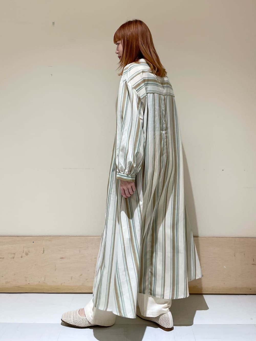 グリーン系のワンピース、ホワイト系のパンプス、ブラック系のショルダーバッグを着用したレディースの春コーディネートの5枚目の写真