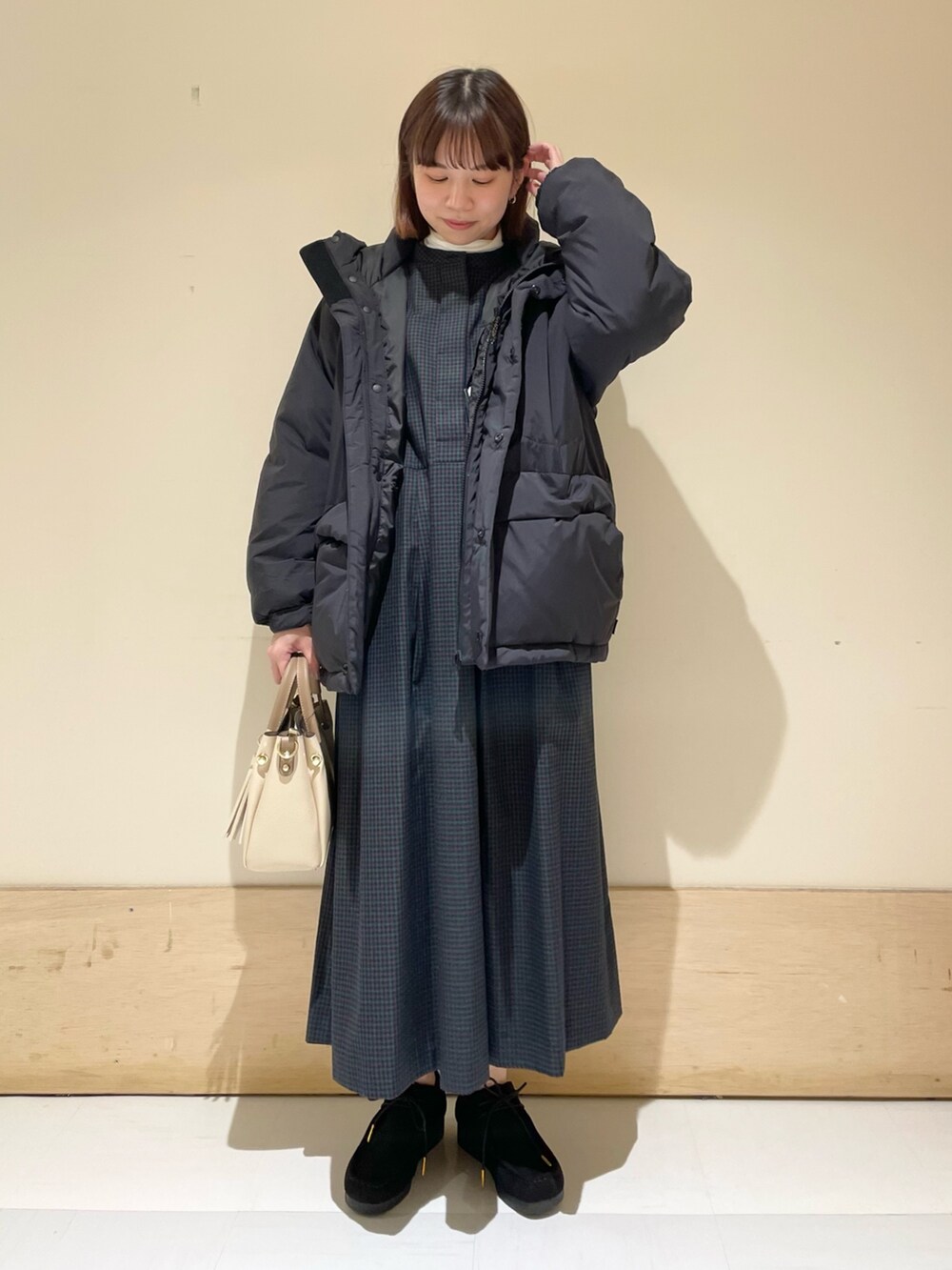 ブルー系のワンピース、ブラック系のダウンジャケット/コート、ホワイト系のTシャツ/カットソーを着用したレディースの冬コーディネートの3枚目の写真