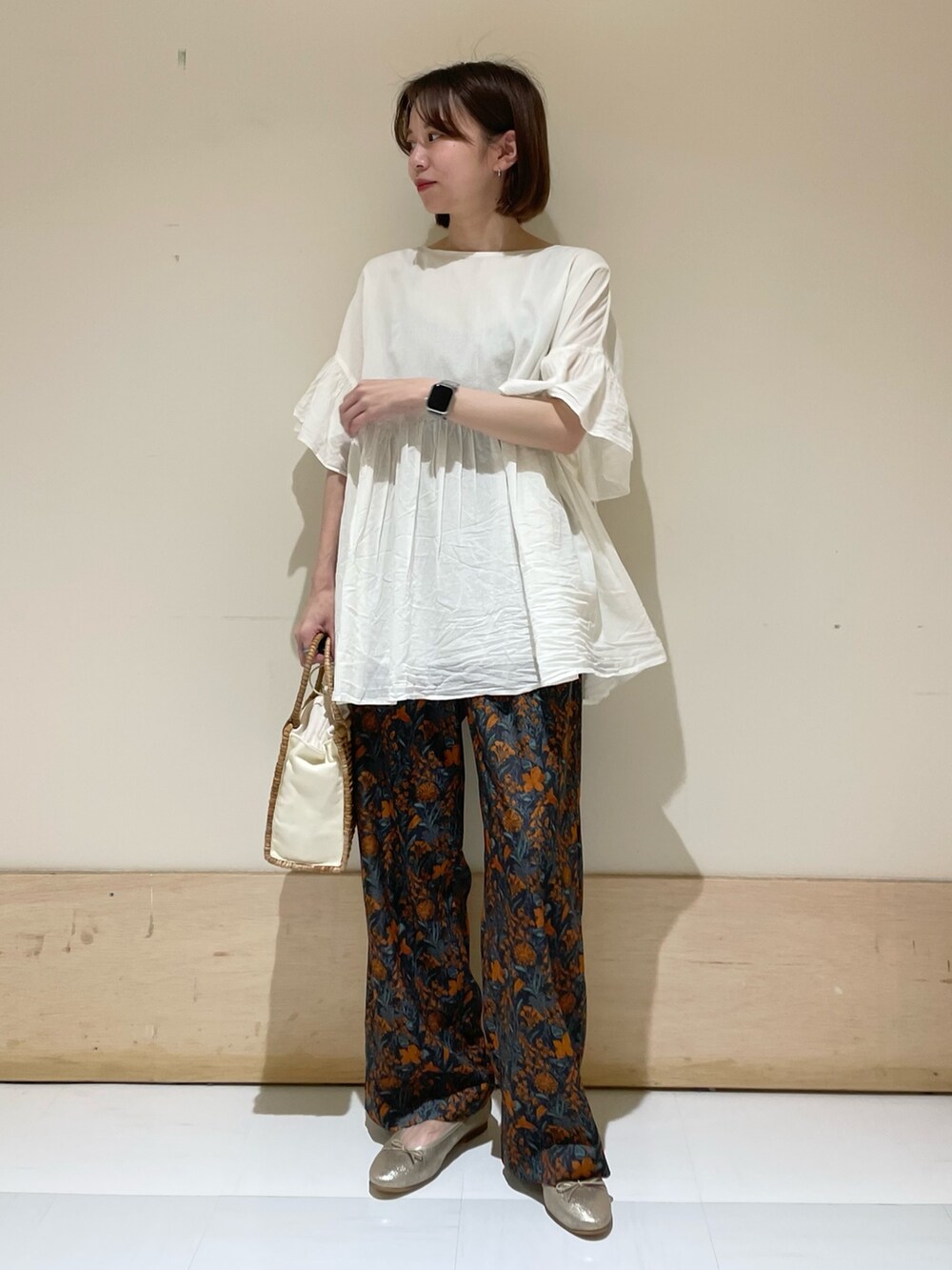 ベージュ系のハンドバッグ、ゴールド系のパンプス、オレンジ系のその他パンツを着用したレディースの夏コーディネートの3枚目の写真