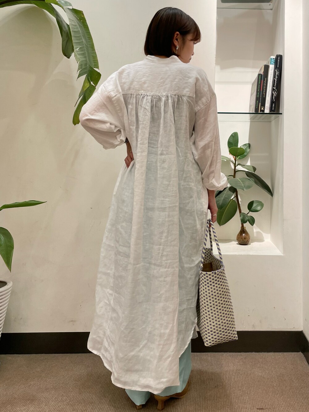 パープル系のトートバッグ、ホワイト系のワンピース、ベージュ系のサンダルを着用したレディースの夏コーディネートの4枚目の写真