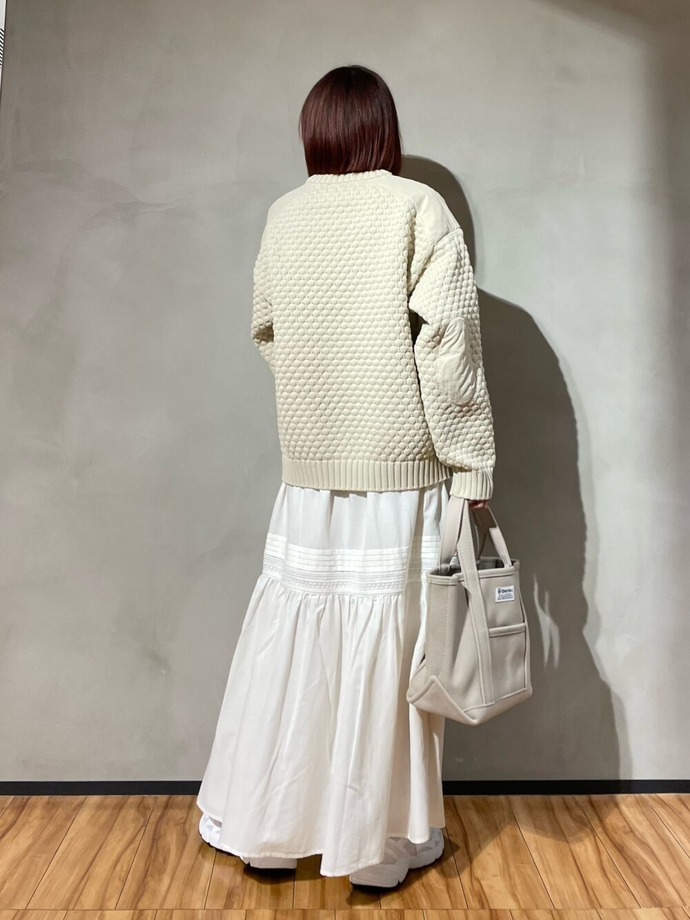 ベージュ系のニット/セーター、ホワイト系のスカートを着用したレディースの秋コーディネートの6枚目の写真