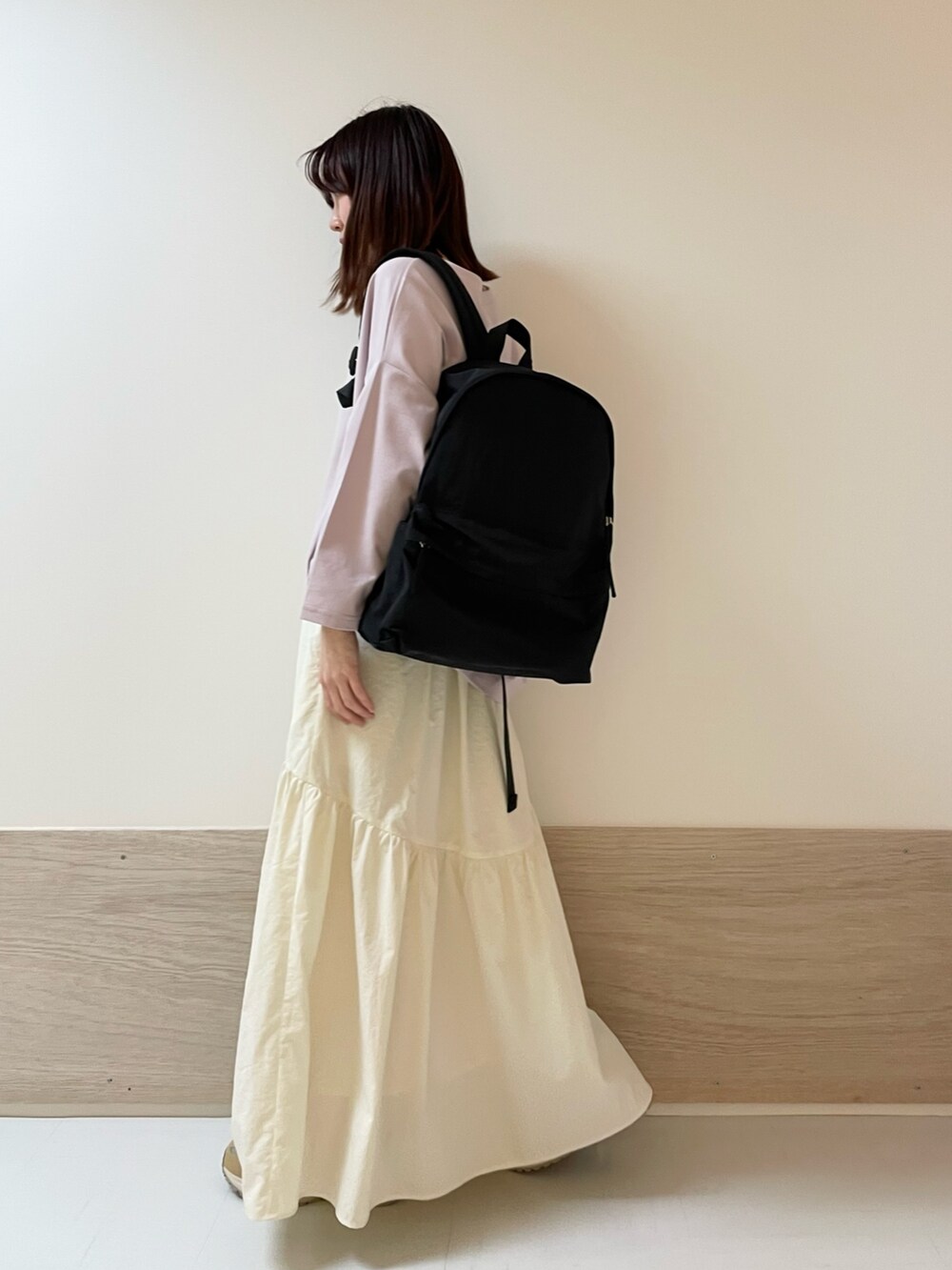 ホワイト系のスカート、ピンク系のTシャツ/カットソー、ベージュ系のスニーカーを着用したレディースの春コーディネートの4枚目の写真