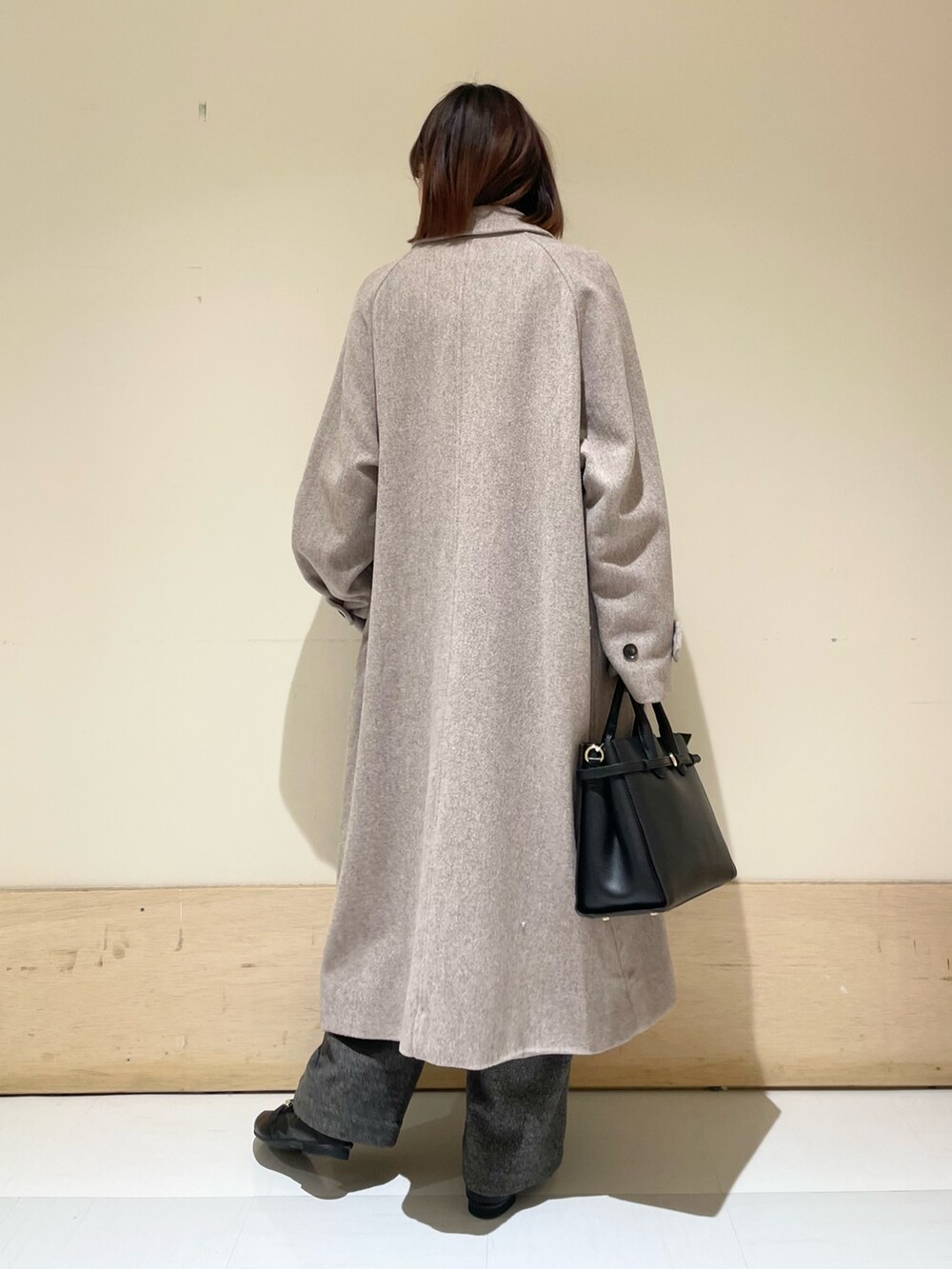 ブルー系のニット/セーター、グレー系のステンカラーコート、グレー系のその他パンツを着用したレディースの冬コーディネートの5枚目の写真
