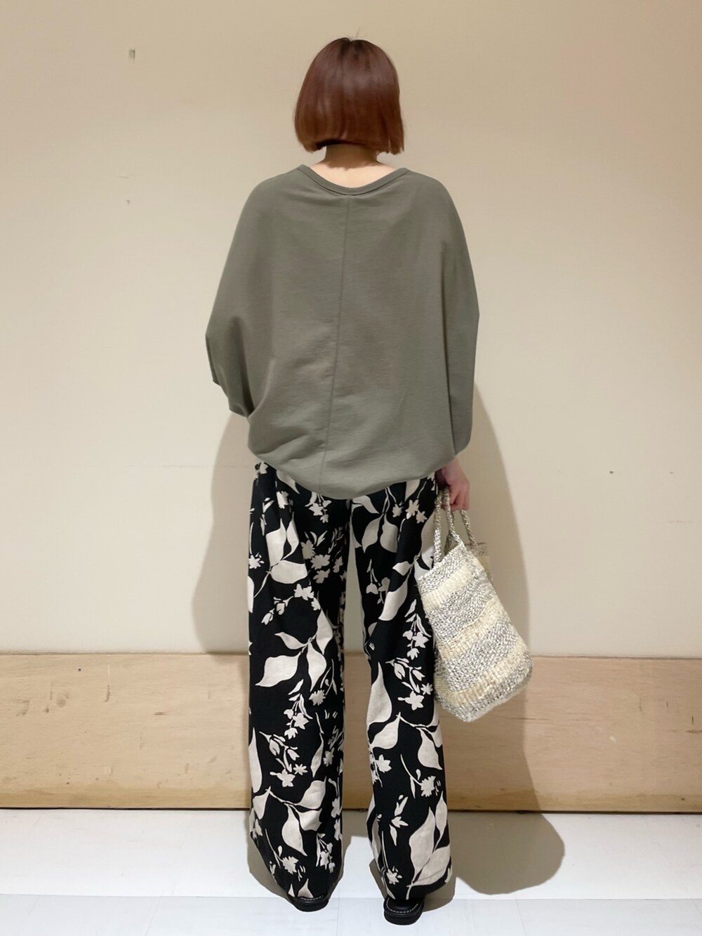 ブラック系のその他パンツ、グリーン系のTシャツ/カットソー、ホワイト系のハンドバッグを着用したレディースの春コーディネートの5枚目の写真