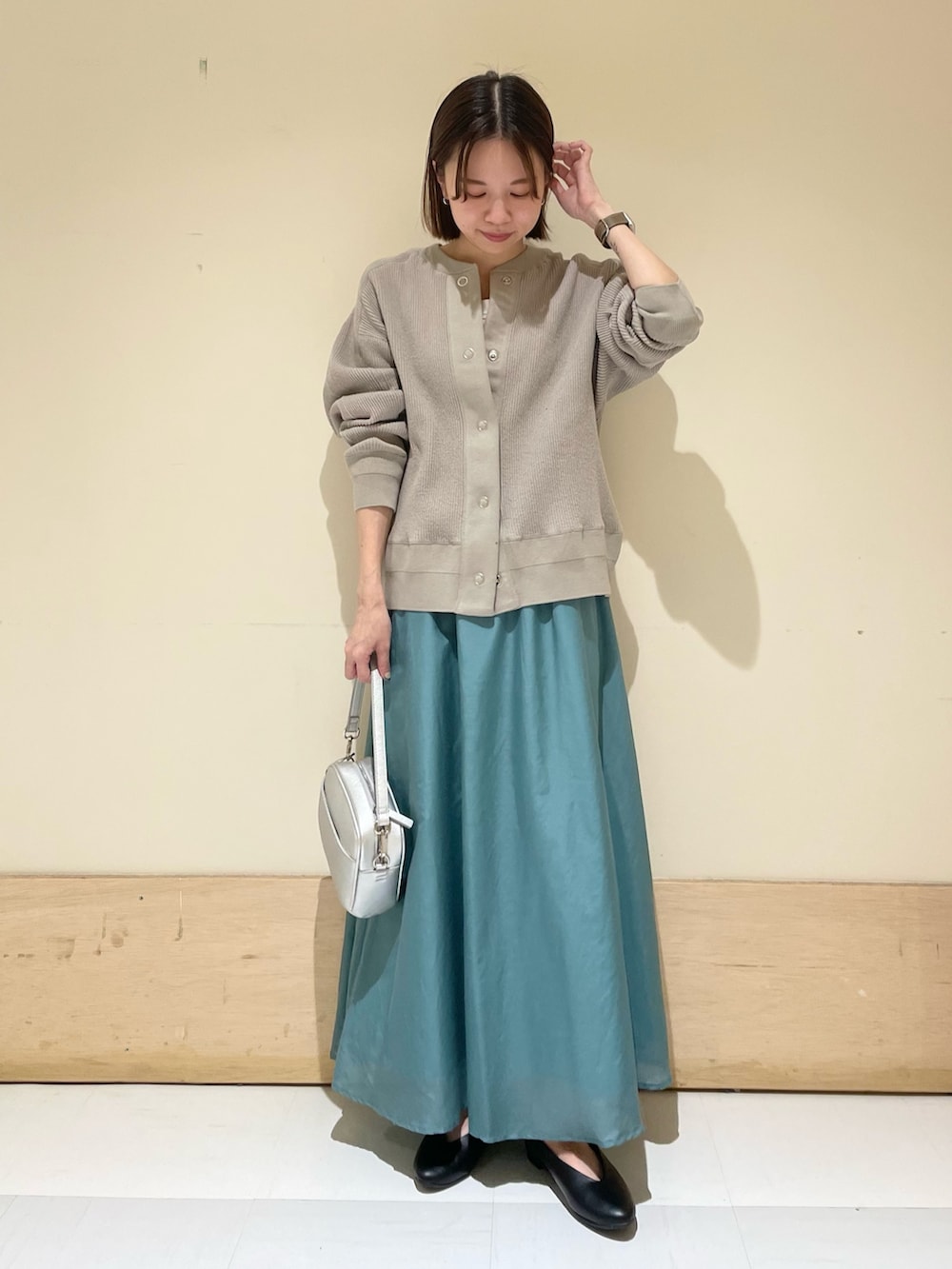 ブラック系のパンプス、シルバー系のショルダーバッグ、グレー系のカーディガン/ボレロを着用したレディースの夏コーディネートの3枚目の写真