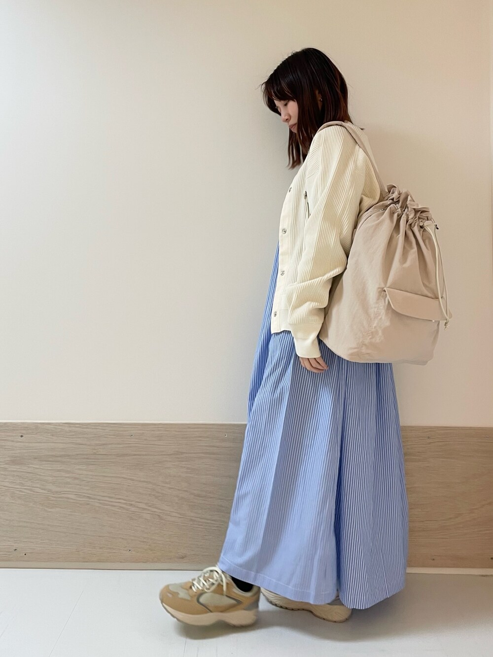 ホワイト系のカーディガン/ボレロ、ベージュ系のスニーカー、ブルー系のワンピースを着用したレディースの春コーディネートの3枚目の写真