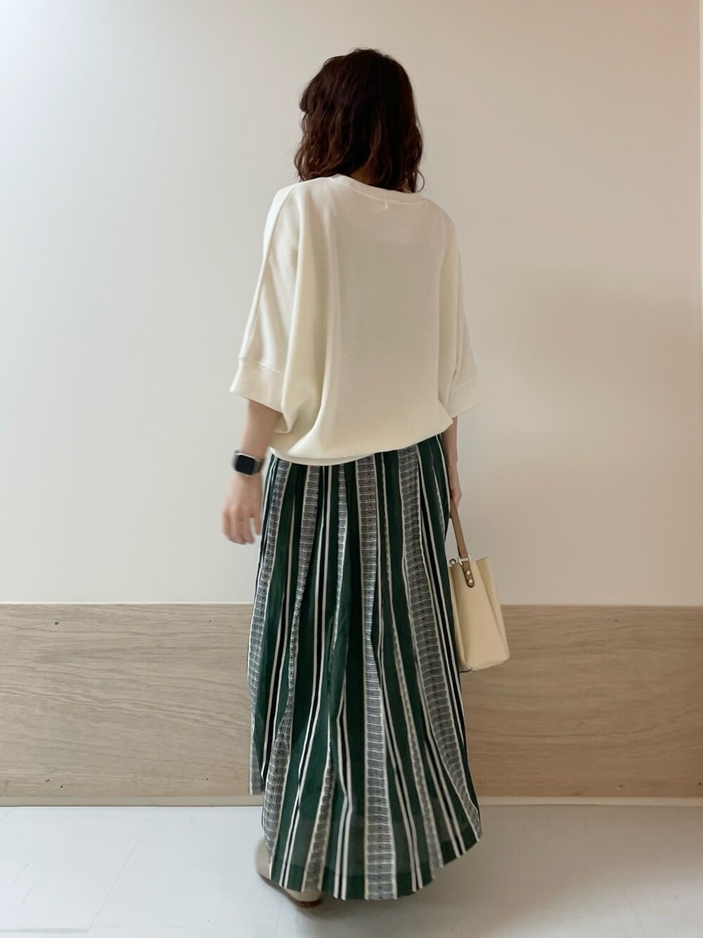 ホワイト系のTシャツ/カットソー、グリーン系のスカート、ベージュ系のパンプスを着用したレディースの春コーディネートの5枚目の写真