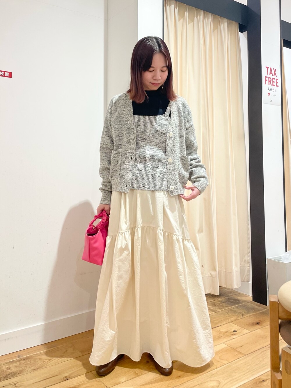 ブルー系のニット/セーター、ブルー系のカーディガン/ボレロ、ホワイト系のスカートを着用したレディースの春コーディネートの3枚目の写真