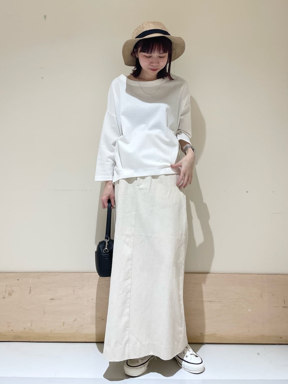 ホワイト系のTシャツ/カットソー、ホワイト系のスニーカー、ブラック系のショルダーバッグを着用したレディースの春コーディネートの3枚目の写真