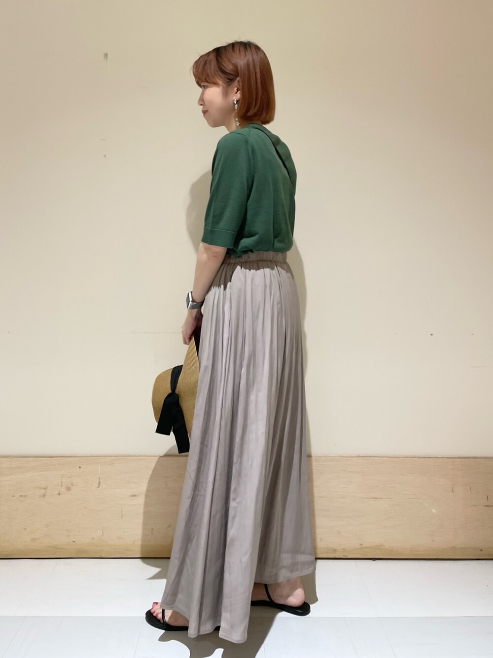 グレー系のスカート、ブラック系のサンダル、ブラック系のショルダーバッグを着用したレディースの春コーディネートの7枚目の写真