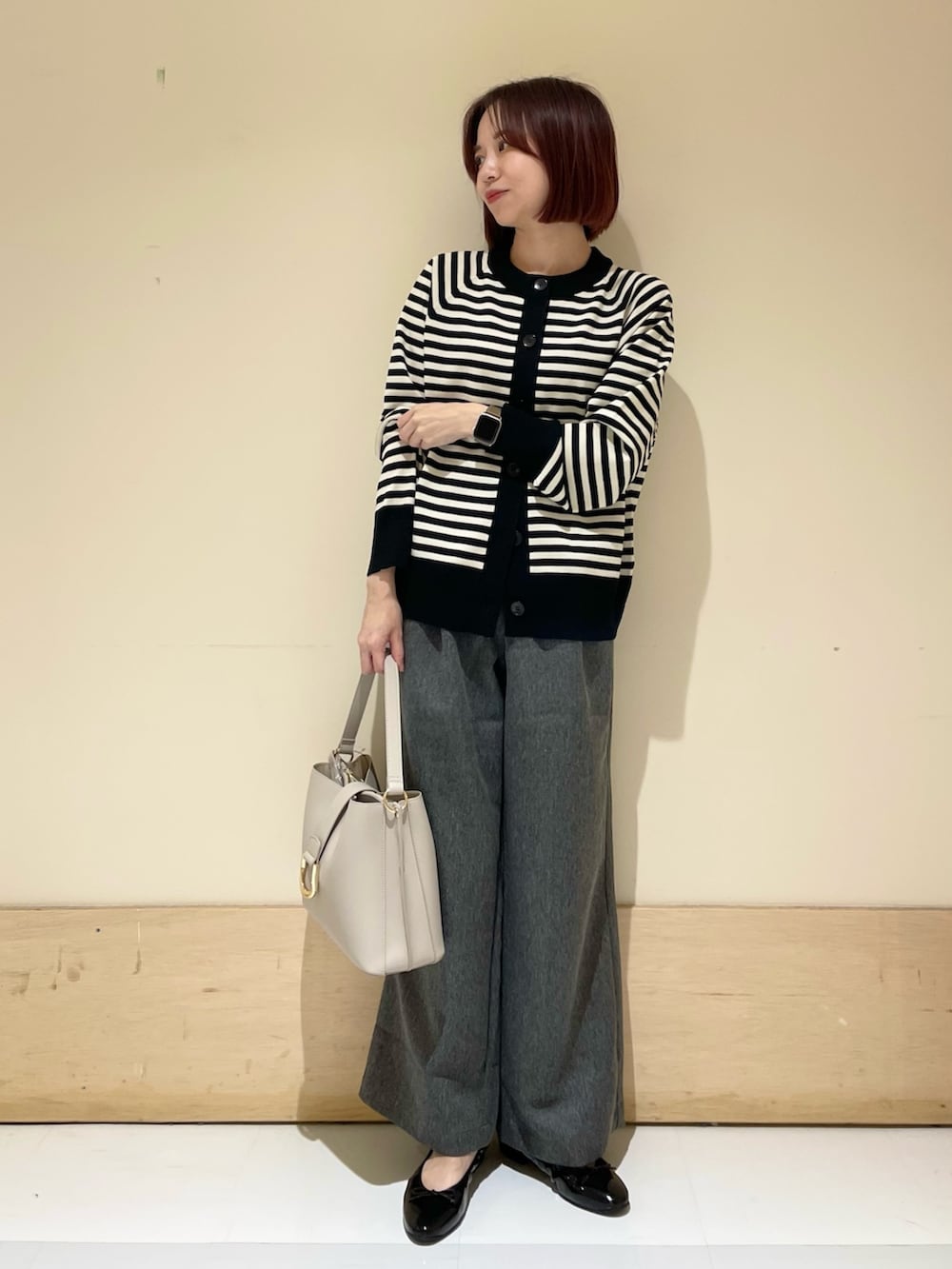 グレー系のその他パンツ、グレー系のハンドバッグ、ブラック系のパンプスを着用したレディースの秋コーディネートの3枚目の写真