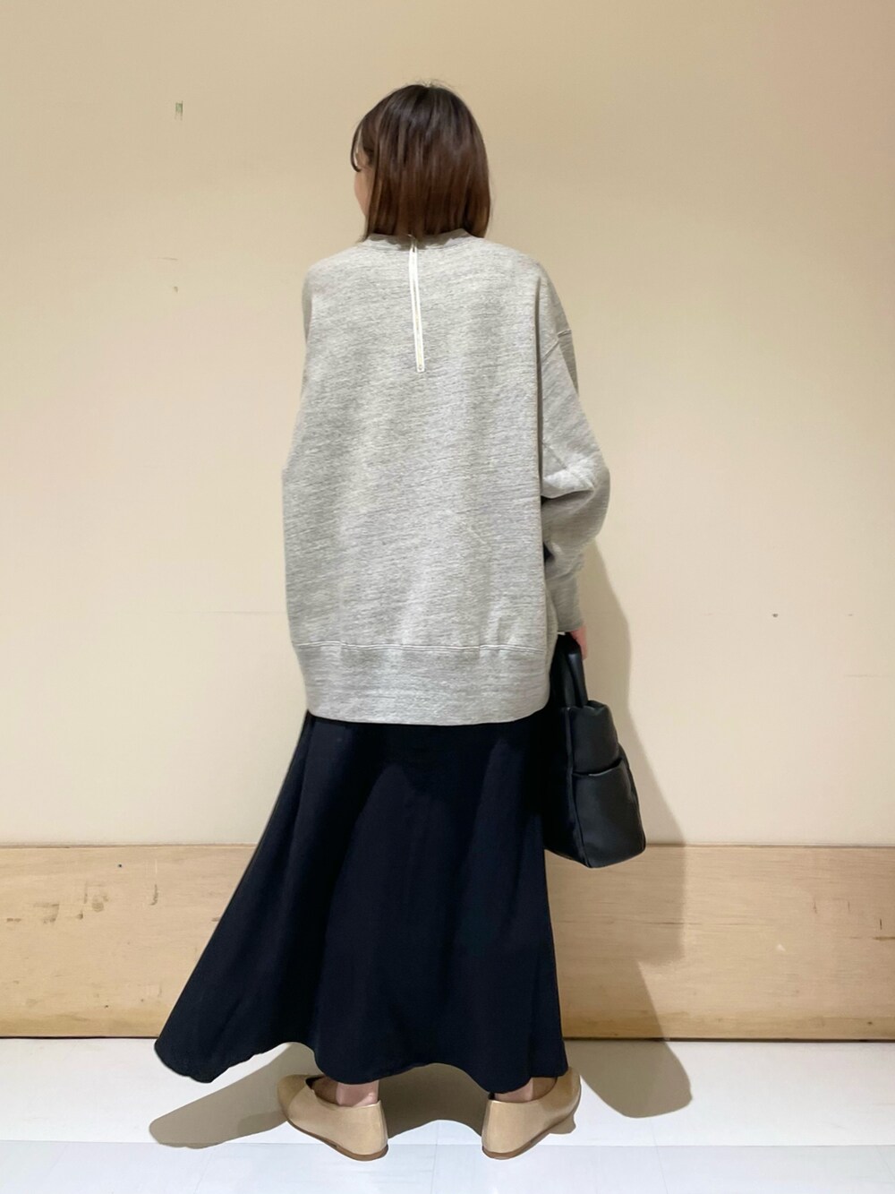 ブラック系のトートバッグ、ゴールド系のパンプス、グレー系のスウェットを着用したレディースの秋コーディネートの6枚目の写真